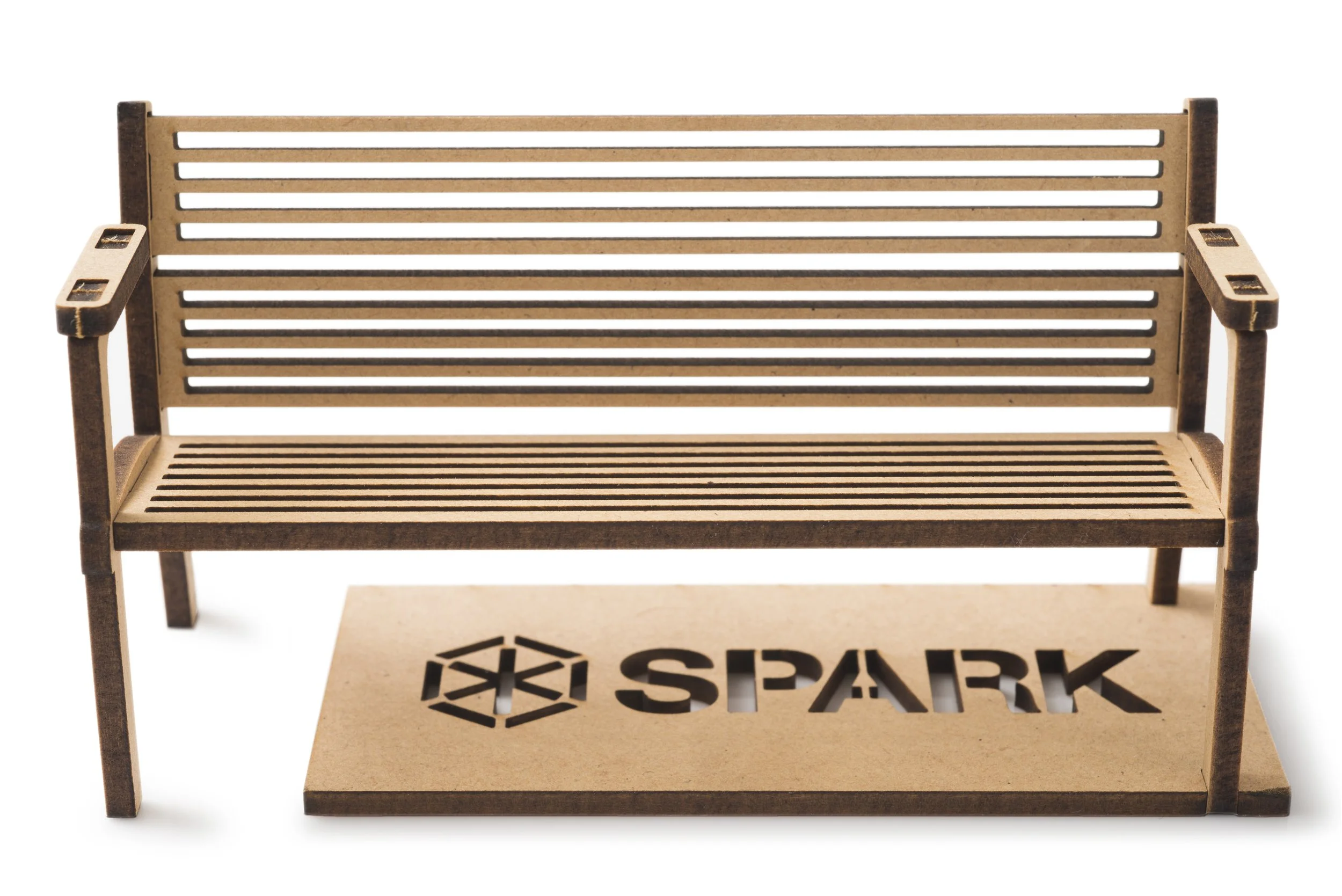 Miniature wooden bench with slatted seat and backrest, placed on a cardboard box with a "SPACE" logo.