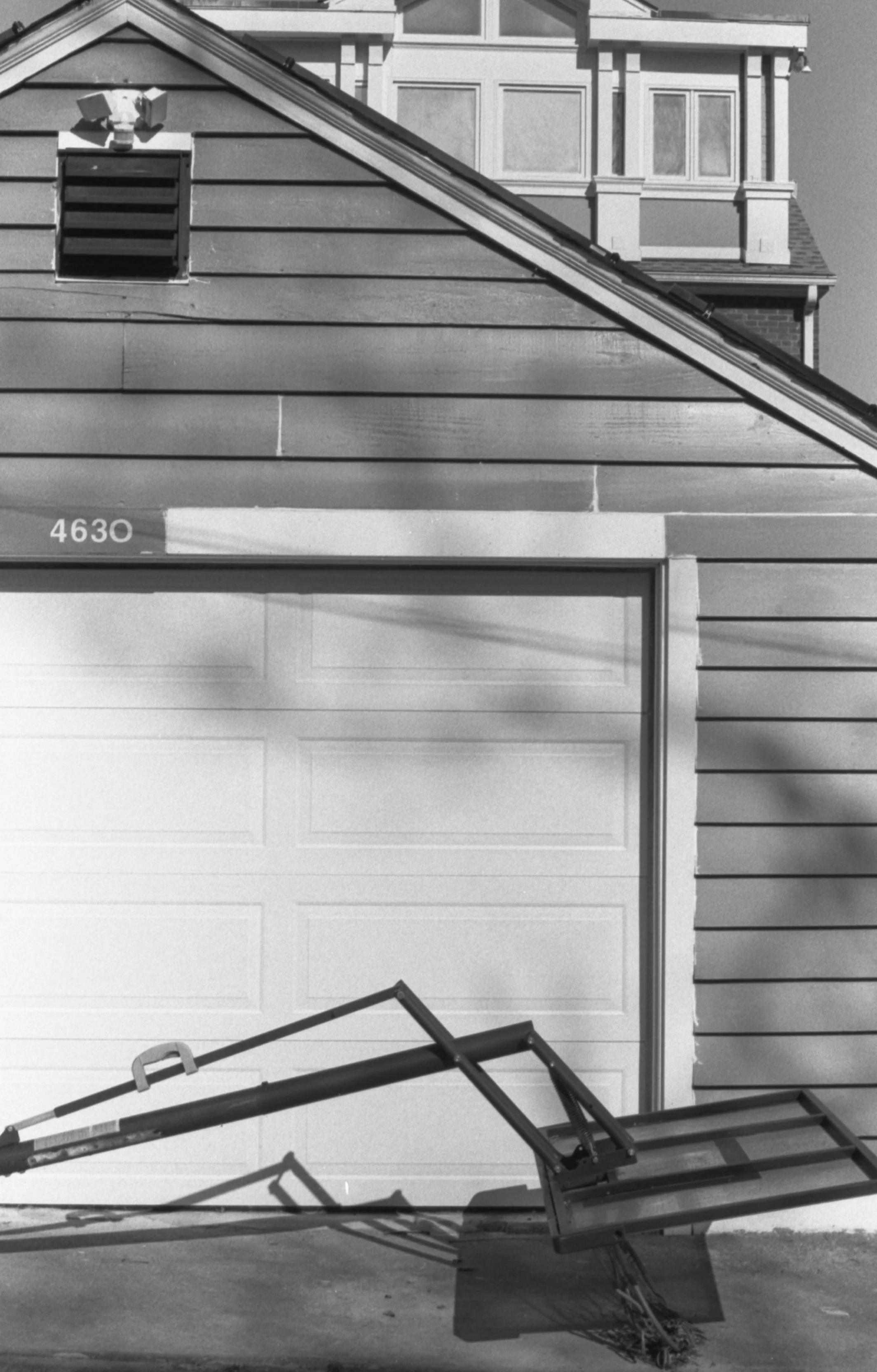 A fallen metal and glass outdoor staircase with a garage door in the background.