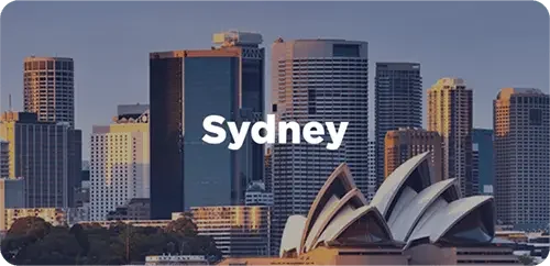 Sydney skyline with the Sydney Opera House in the foreground and tall skyscrapers in the background.