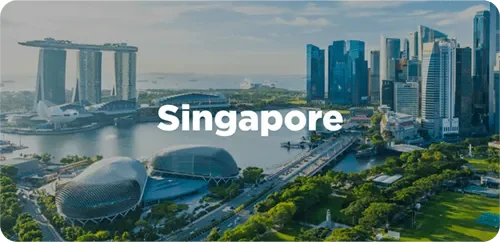 Aerial view of Singapore skyline with Marina Bay Sands hotel, ArtScience Museum, and modern skyscrapers along the waterfront.