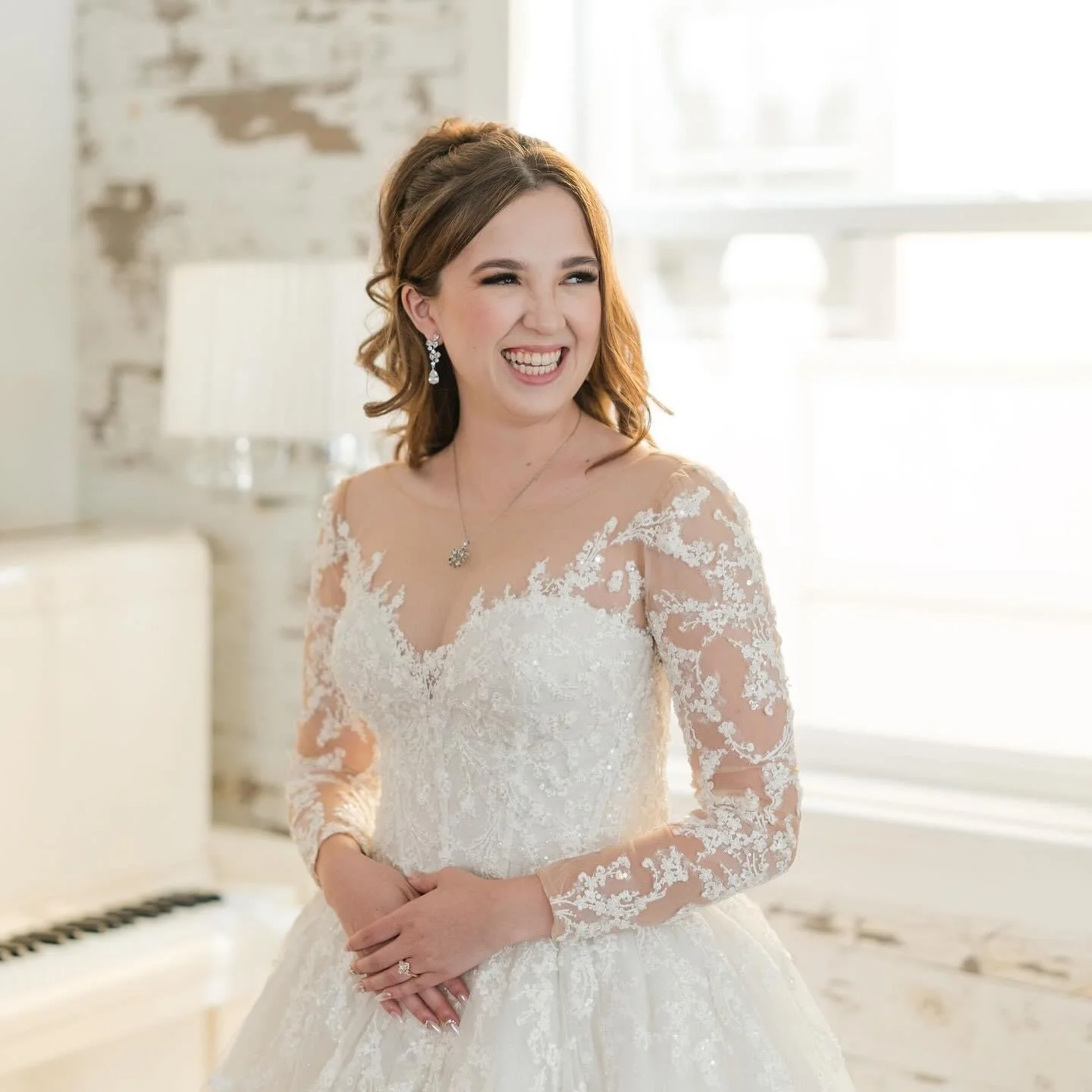 bride with soft glam makeup and romantic half up hairstyle wearing a lace wedding dress at Maravilla Gardens in Camarilo