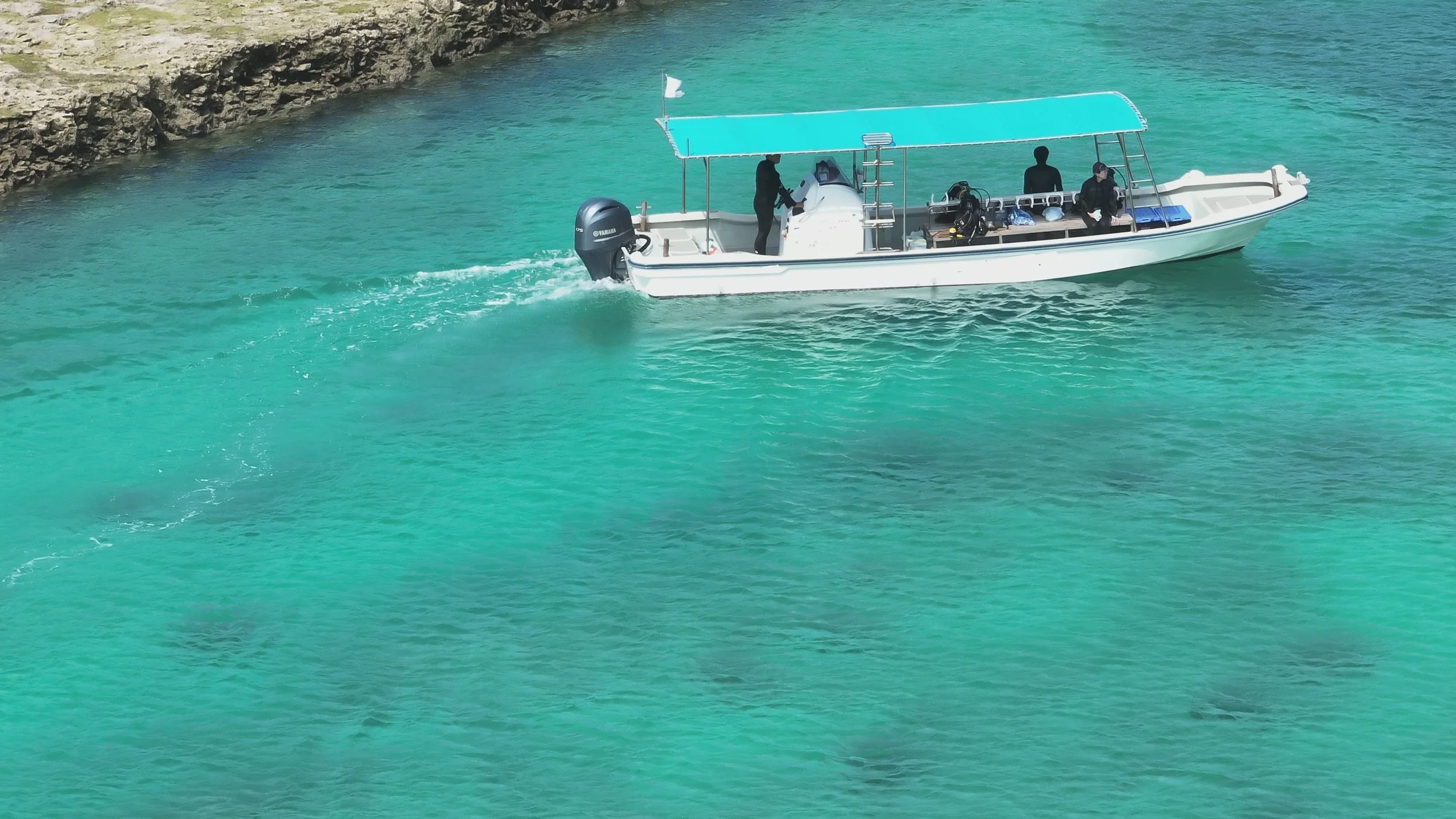 青い屋根のボートが海を走っている。