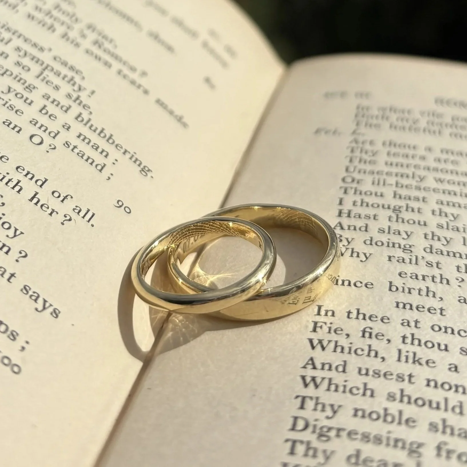 Close-up of a golden wedding ring placed on an open book with text.