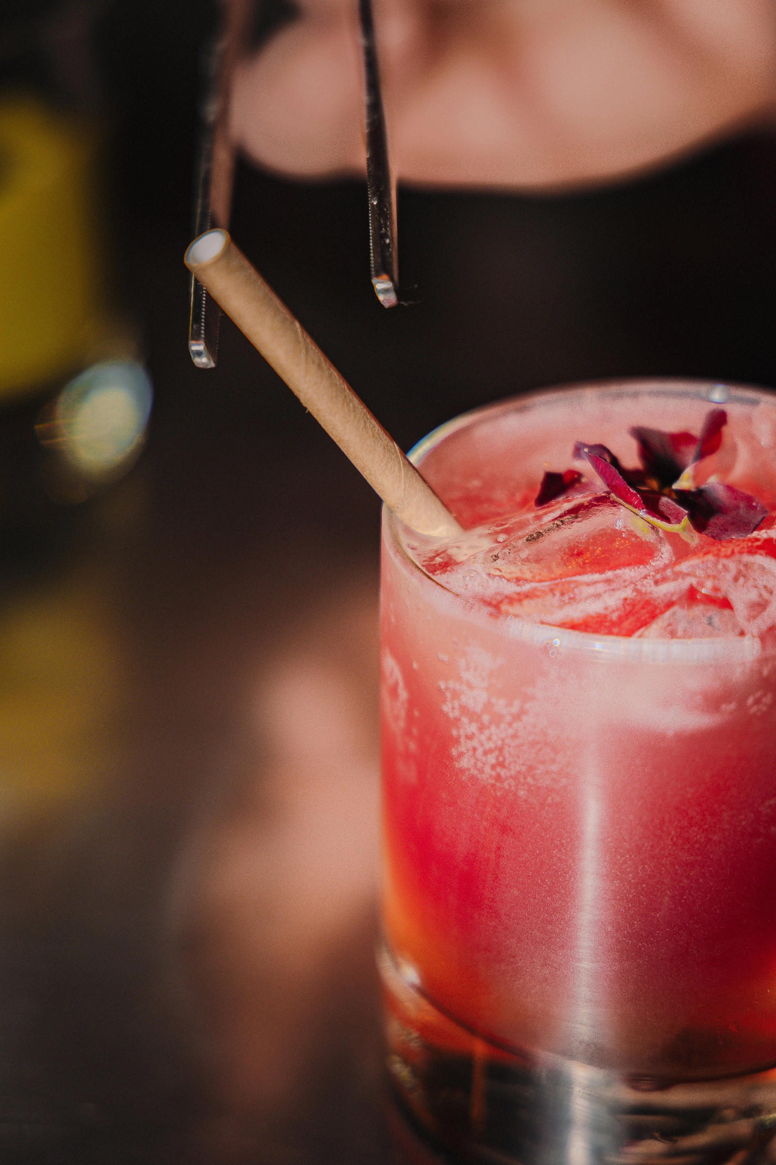 Un cocktail rose avec glaçons, à base de gingembre et de Piri Piri