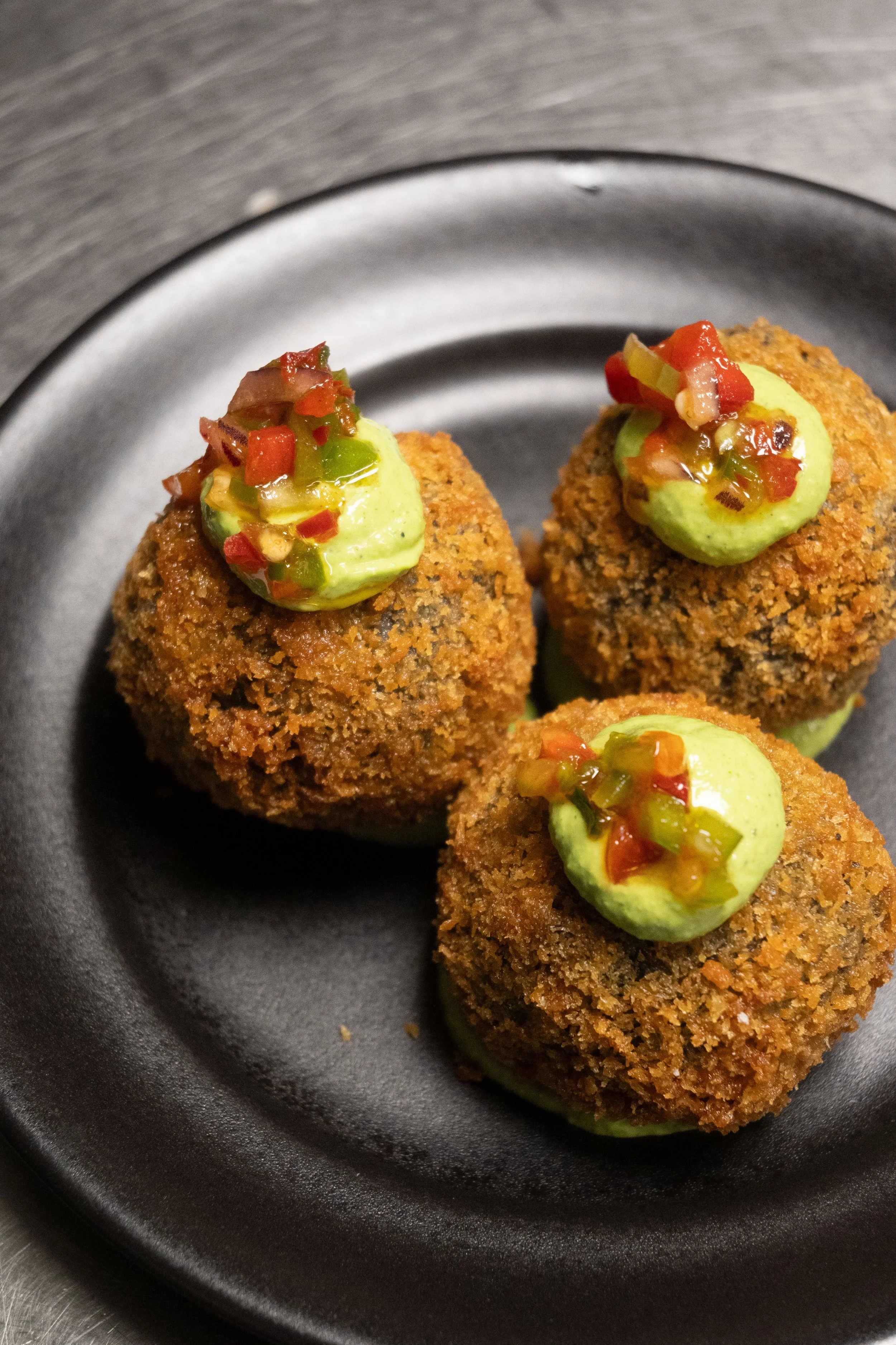 Arancini de riz djondjon haïtien, sauce verte africaine, brunois de poivrons multicolores