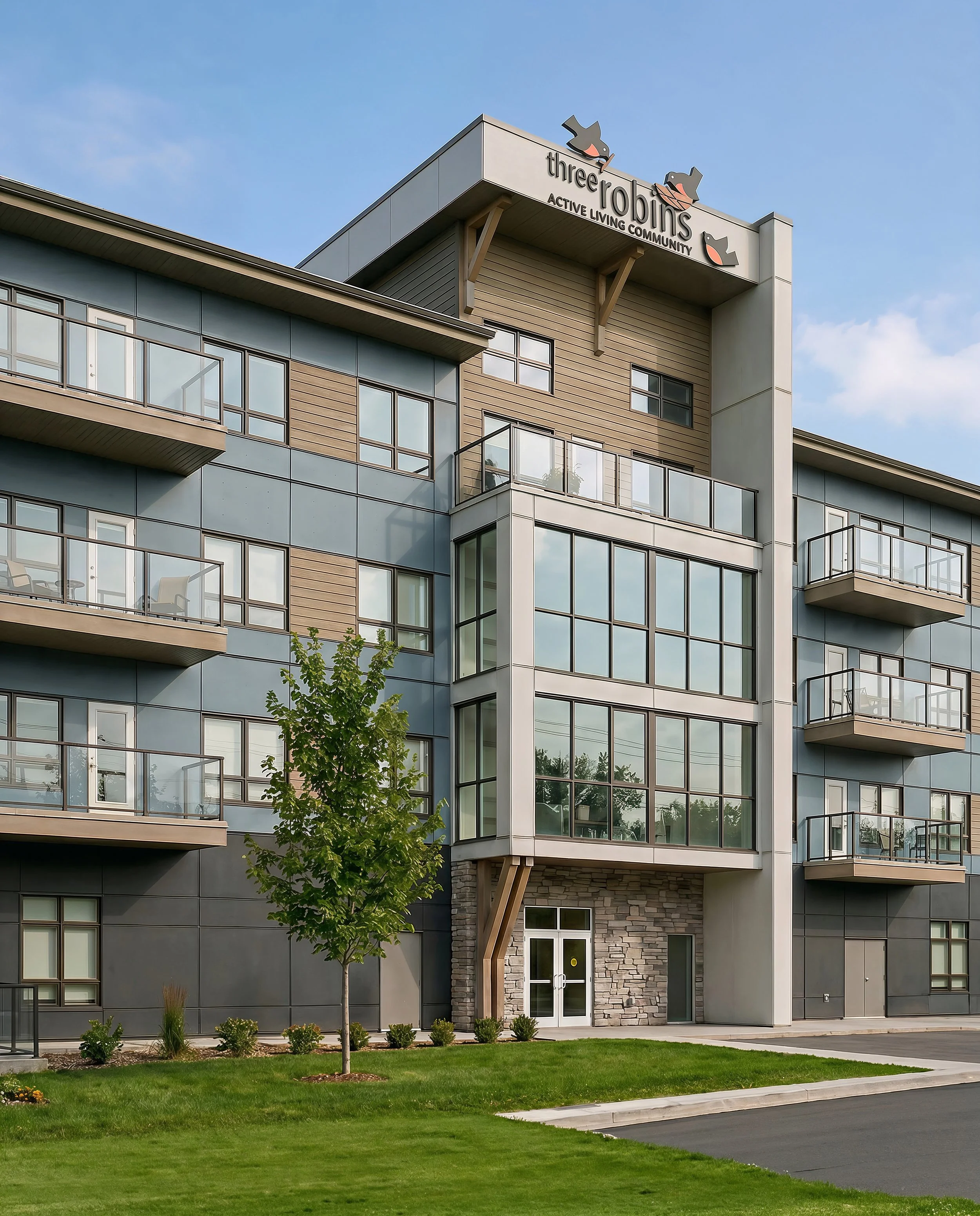 Modern multi-story residential building with large windows and balconies, a small landscaped front yard with a tree and green grass, under a blue sky.