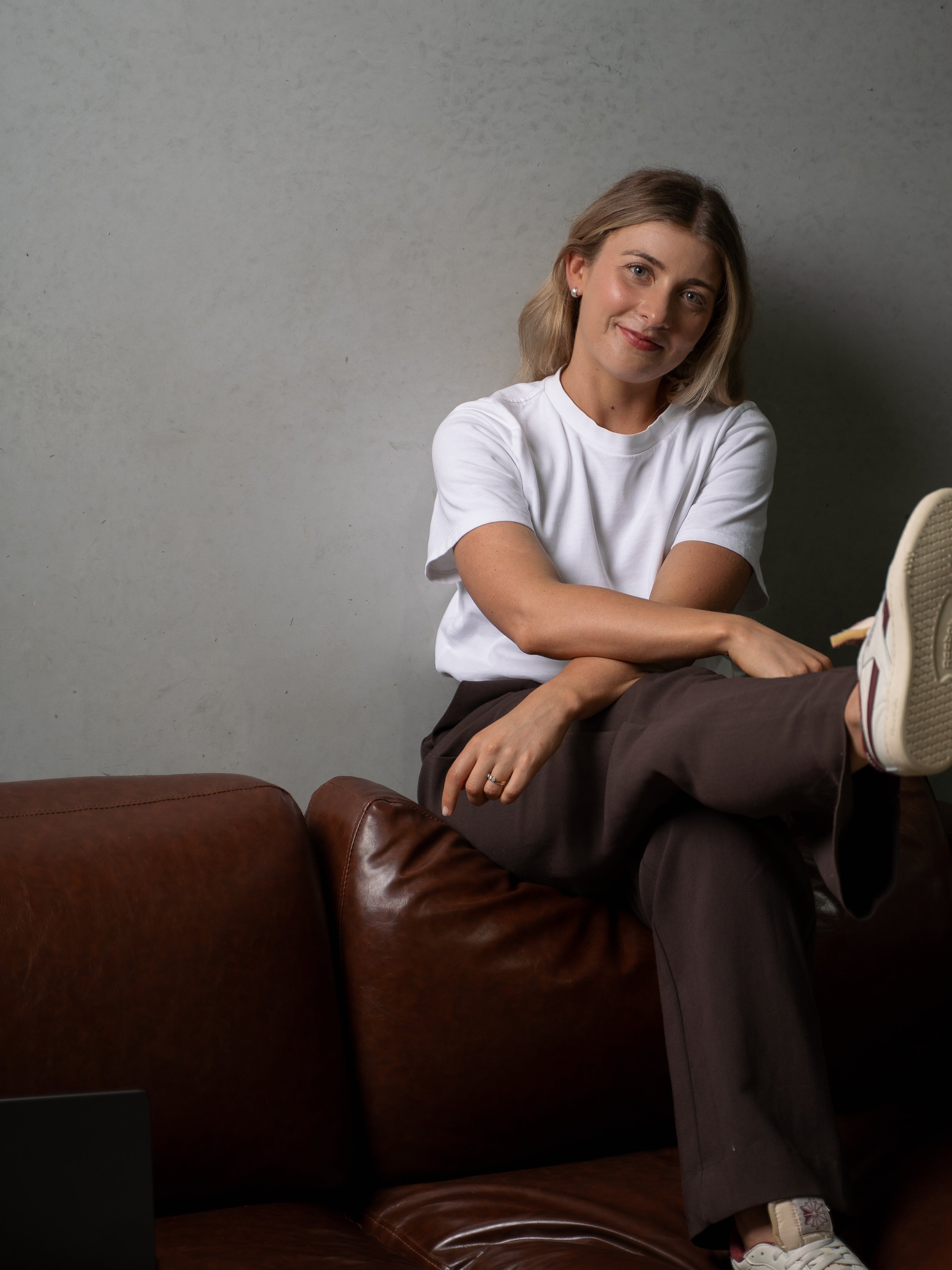 Issy from IS Virtual, practice management consultant for psychologists, seated on leather couch