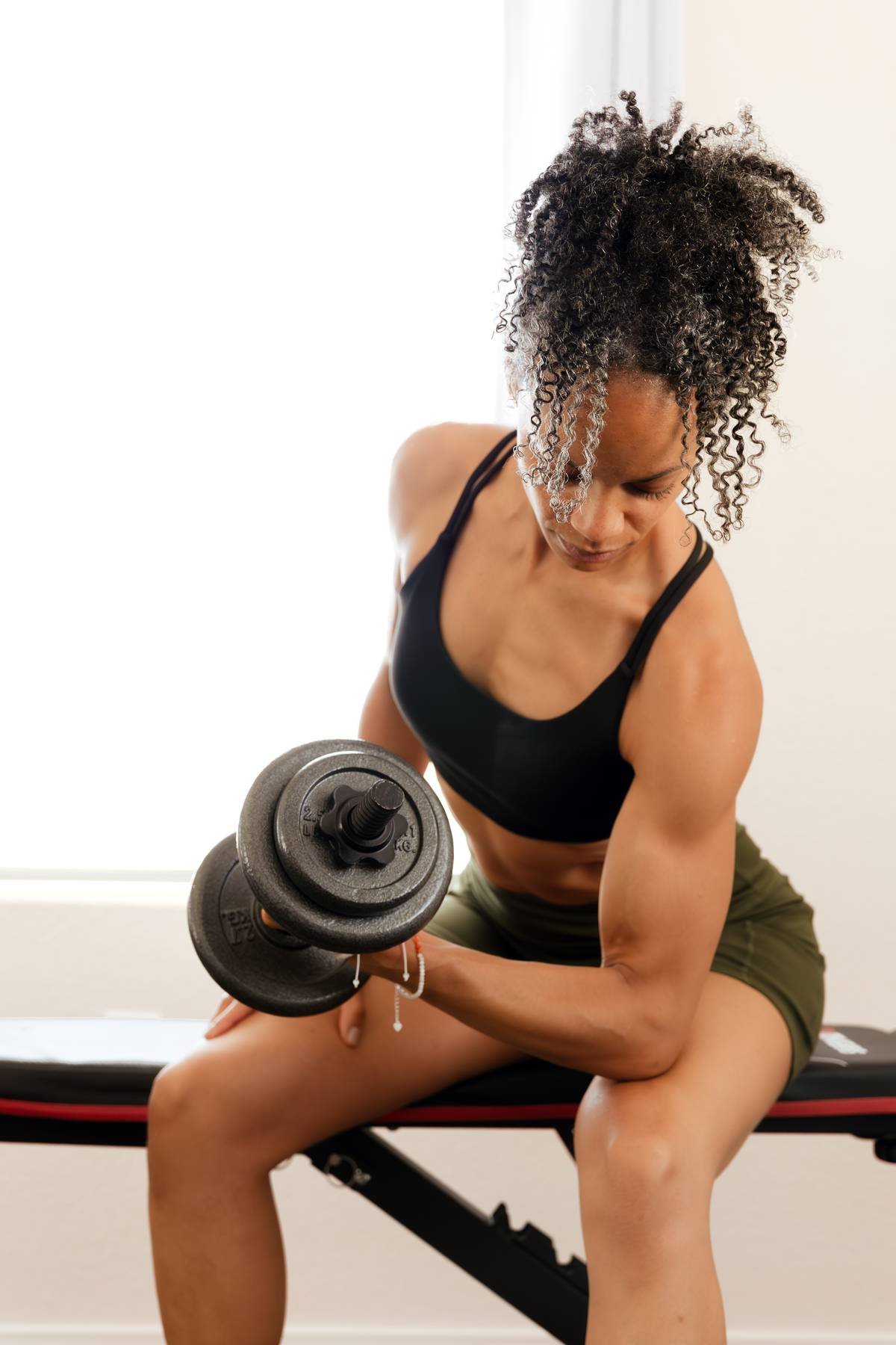 Nixa performing a strength training exercise with a dumbbell