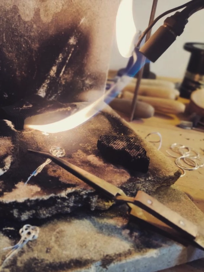 Travail de soudure avec flamme bleue sur un espace de travail avec des outils