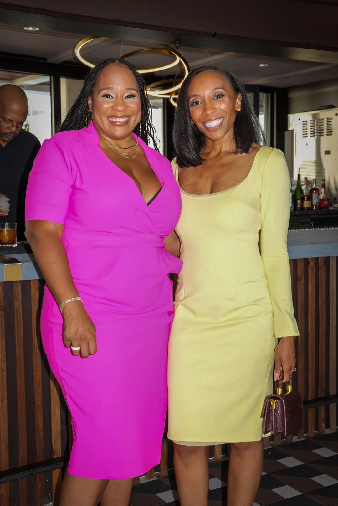 CEO, Ashley Page, standing with guest in yellow dress. 