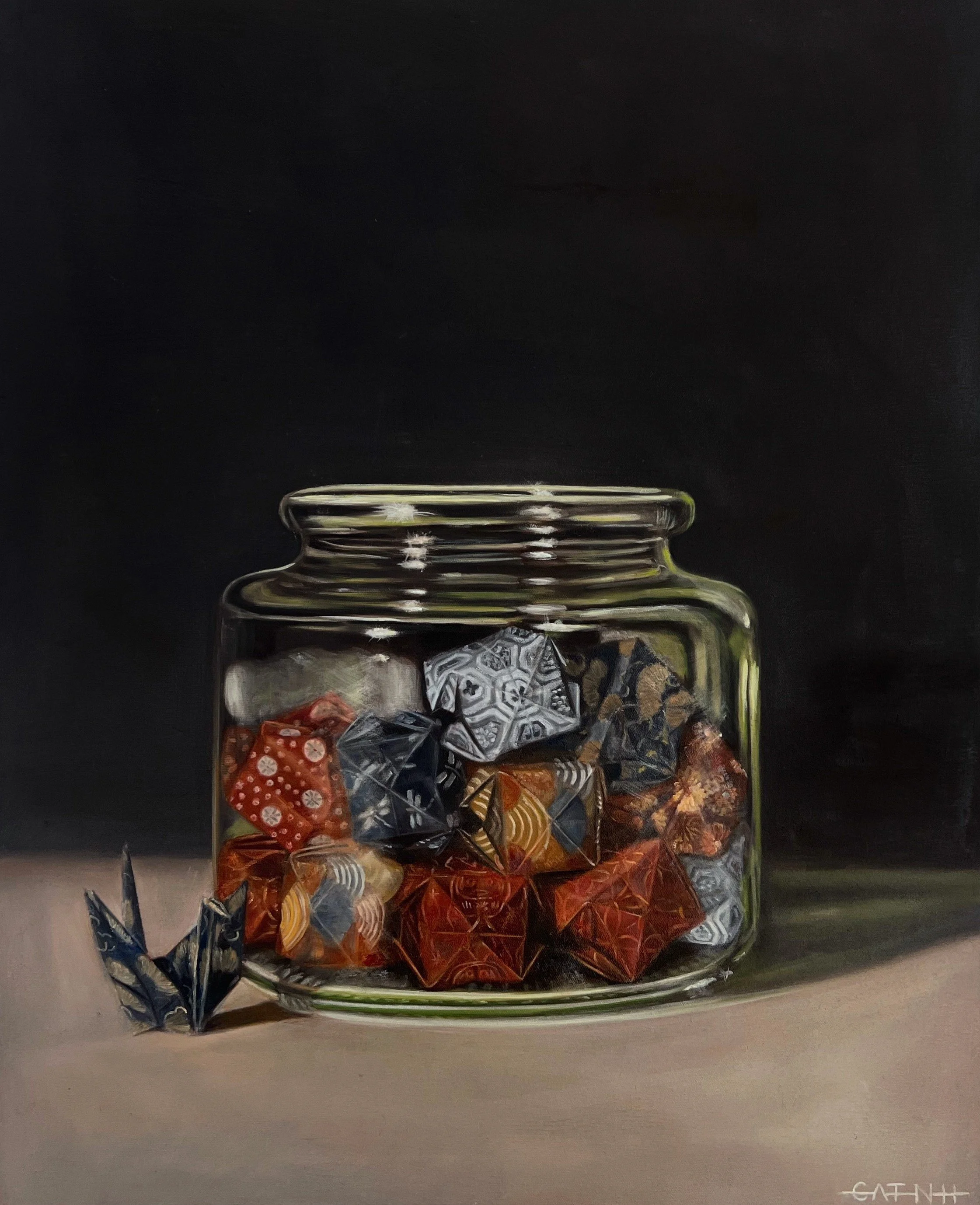 A glass jar filled with wrapped candies of various colors and patterns, sitting on a surface with a dark background.