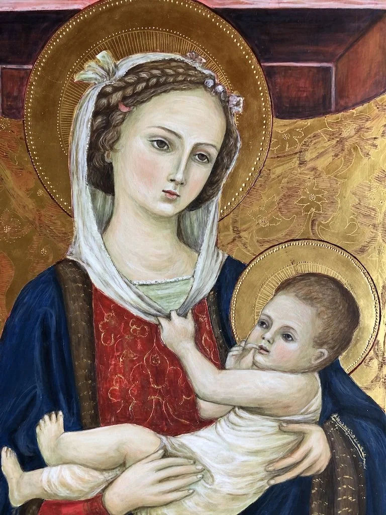 Painting of the Virgin Mary holding baby Jesus, both with golden halos, set against a golden background with intricate details.