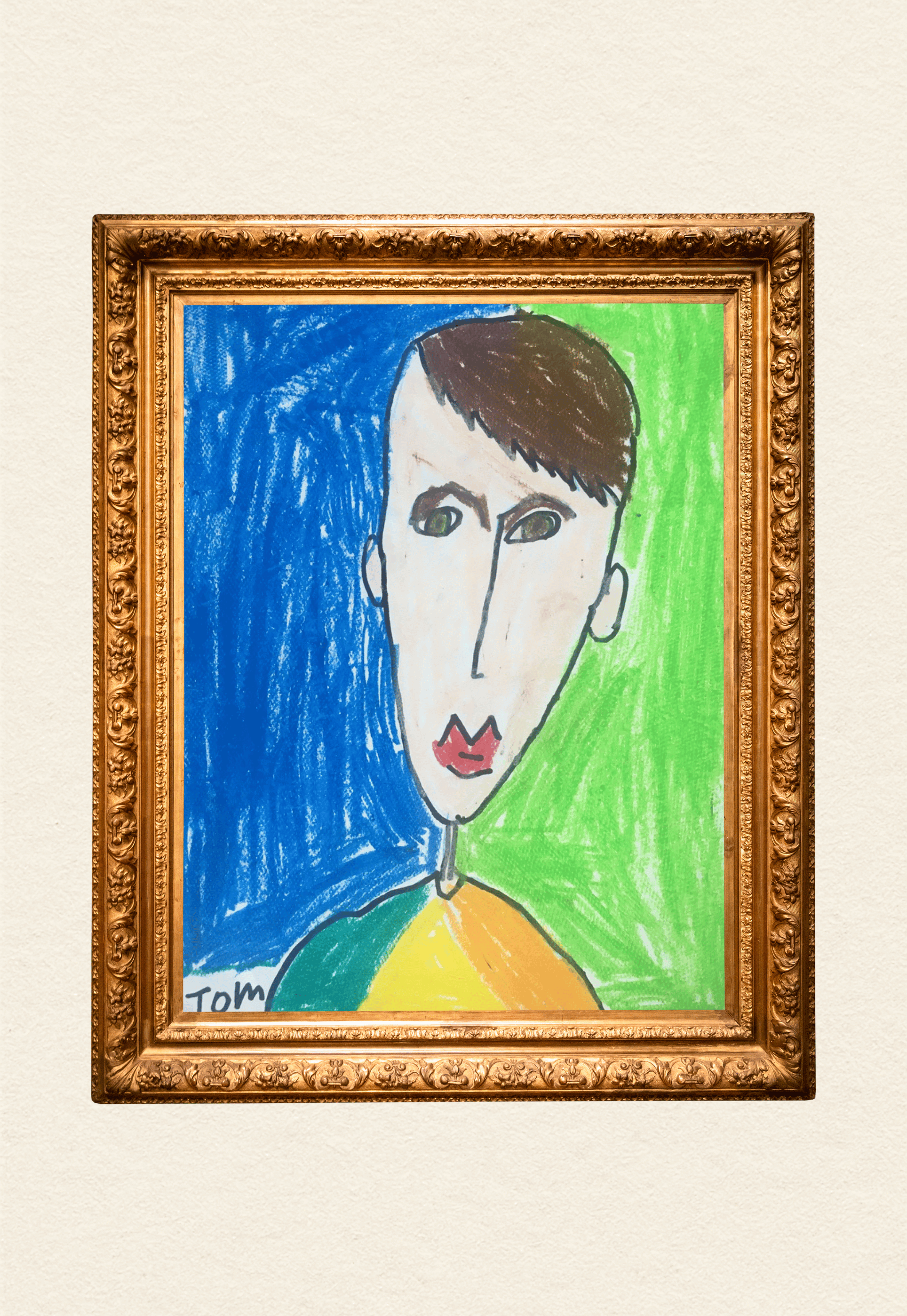 Child's colorful drawing of a person's face, divided into two halves with a green background on the right and a blue background on the left, framed in an ornate gold frame, with the name "Tom" written at the bottom.