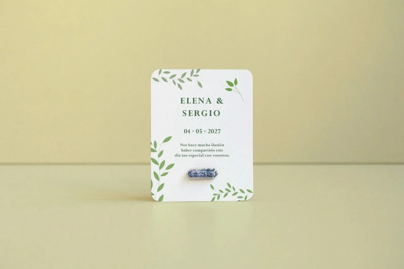 Tarjeta de invitación de boda con nombres Elena y Sergio, fecha 4 de mayo de 2027, con diseño de hojas verdes