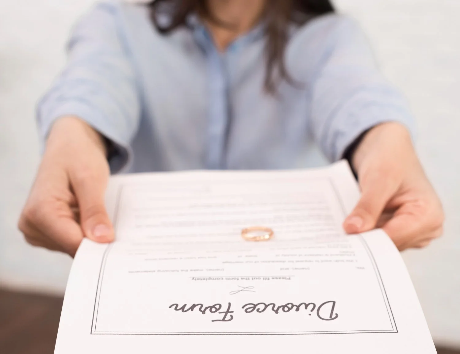 Persona entregando un diploma de graduación con la firma y texto visible.