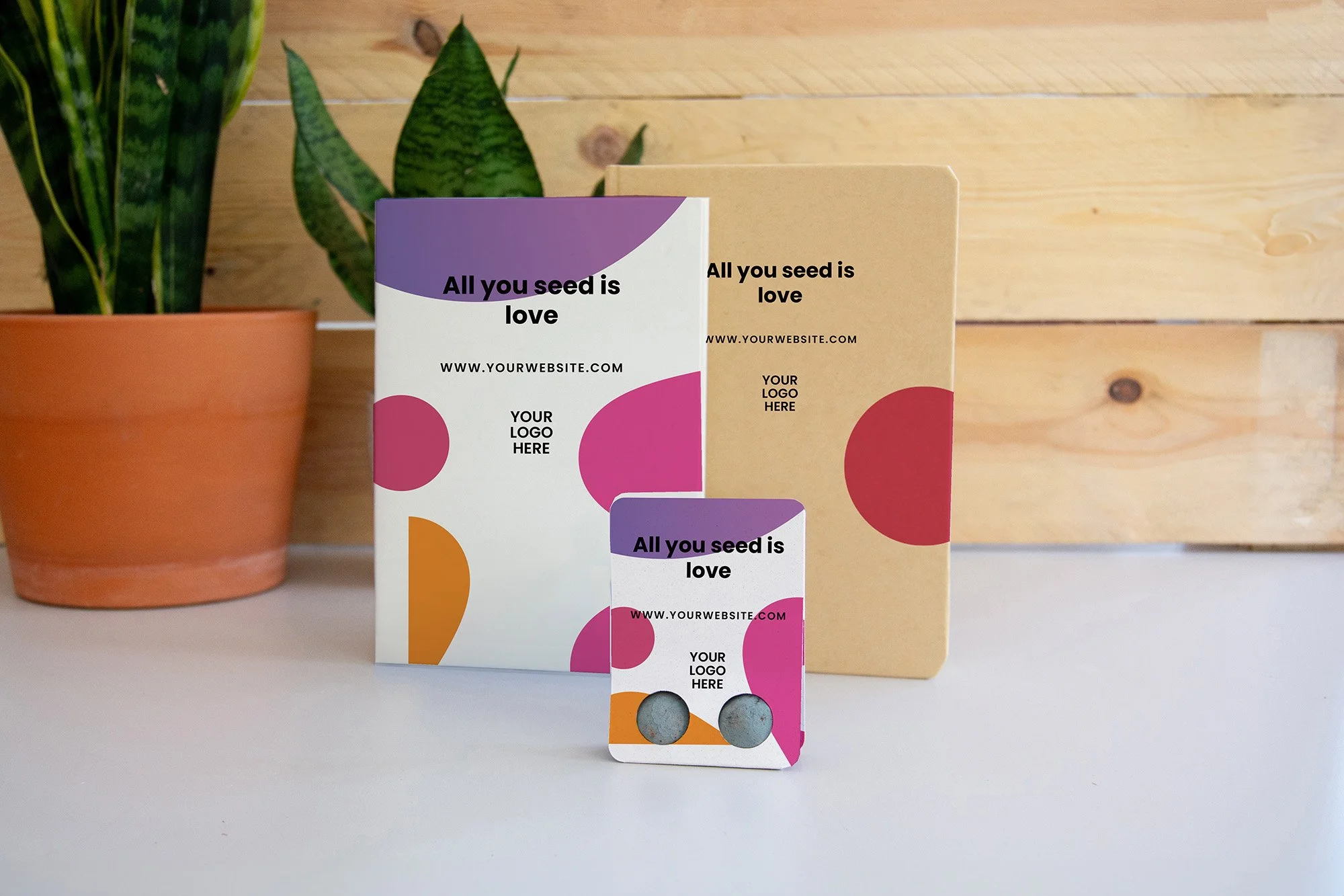 Libretas y un blíster con dos seedbombs de semillas con un diseño de empresa.