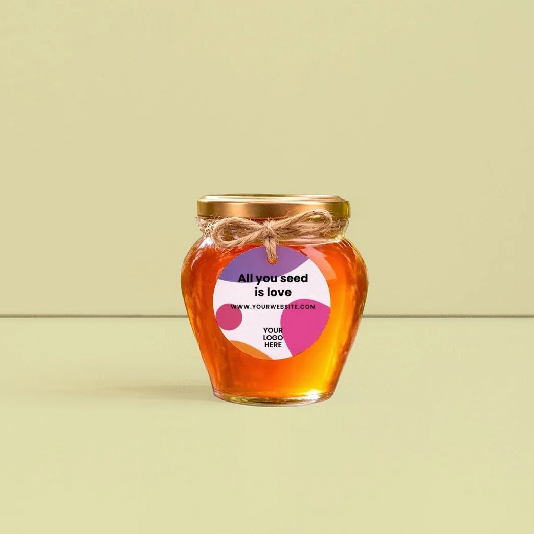 Tarro de miel con etiqueta que dice 'All you seed is love' y espacio para logo, sobre fondo amarillo claro.