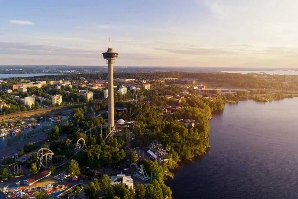Ilmakuva kaupungista, jossa näkyy suuri näkötorni ja huvipuisto lähellä vettä.