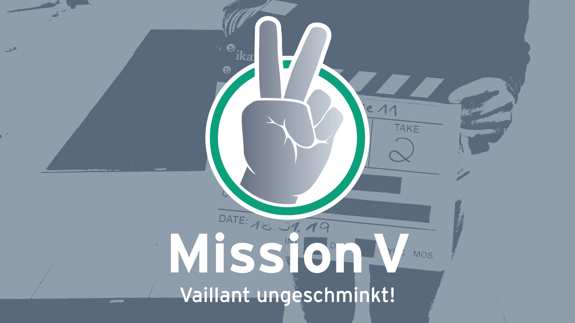 A logo featuring a hand making the victory sign with two fingers, set inside a circular green border. Behind the logo, there is a film clapperboard and a person holding additional clapperboards in the background. The text reads "Mission V" with a slogan in German, "Vaillant ungeschminkt!".