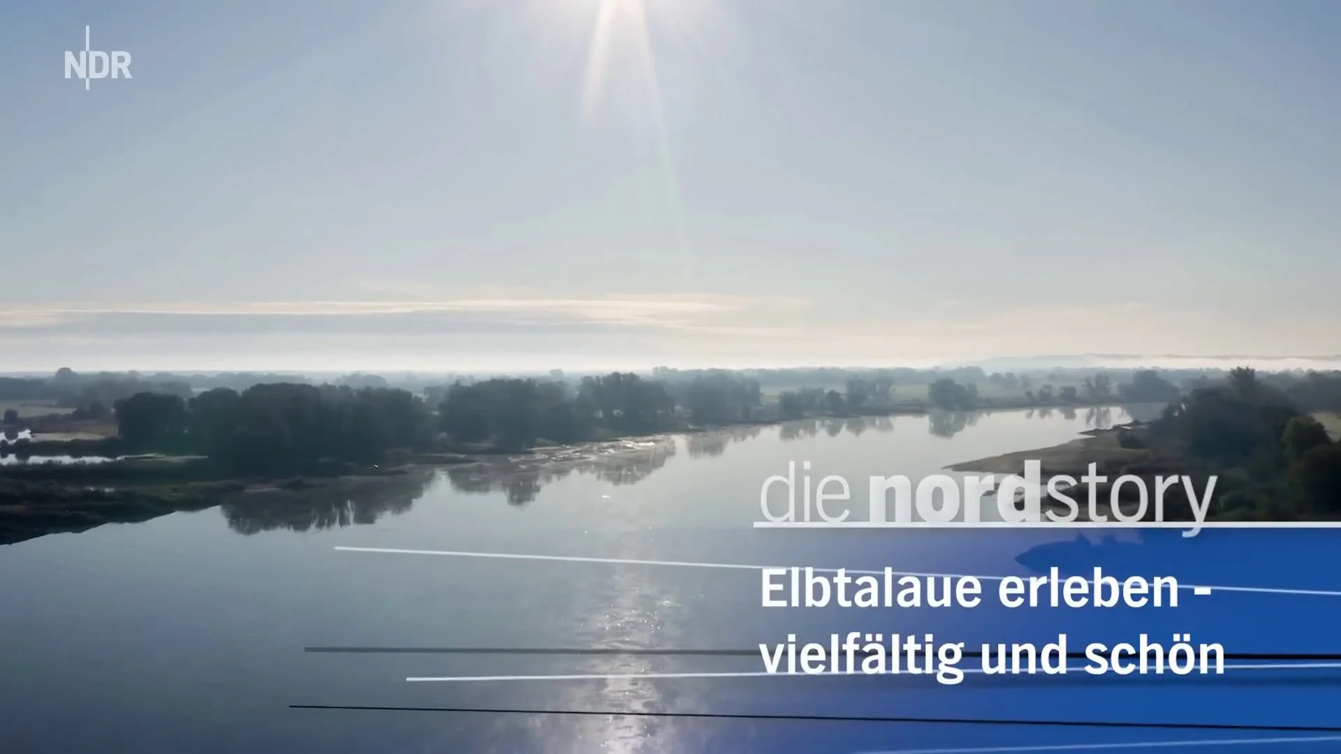 A river was calm with trees and land along its banks, under a clear sky with the sun shining, and text in German about experiencing the Elbe River valley.