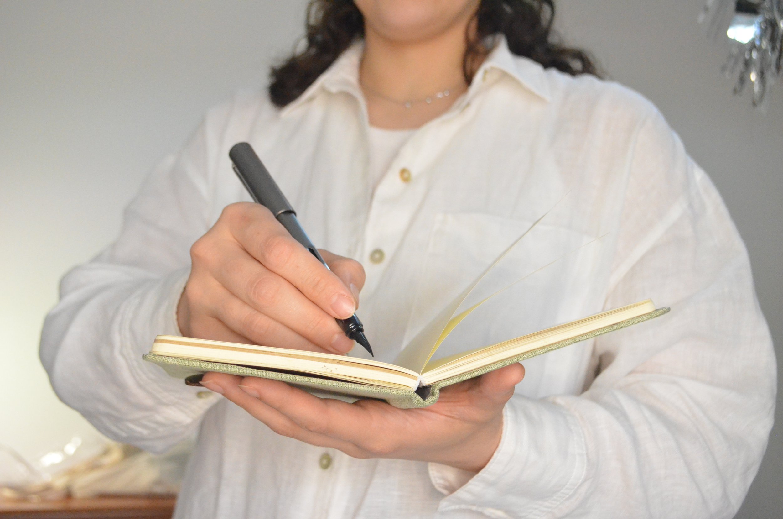 Imagen de la psicóloga escribiendo con una pluma sobre una libreta, psicología, Barcelona