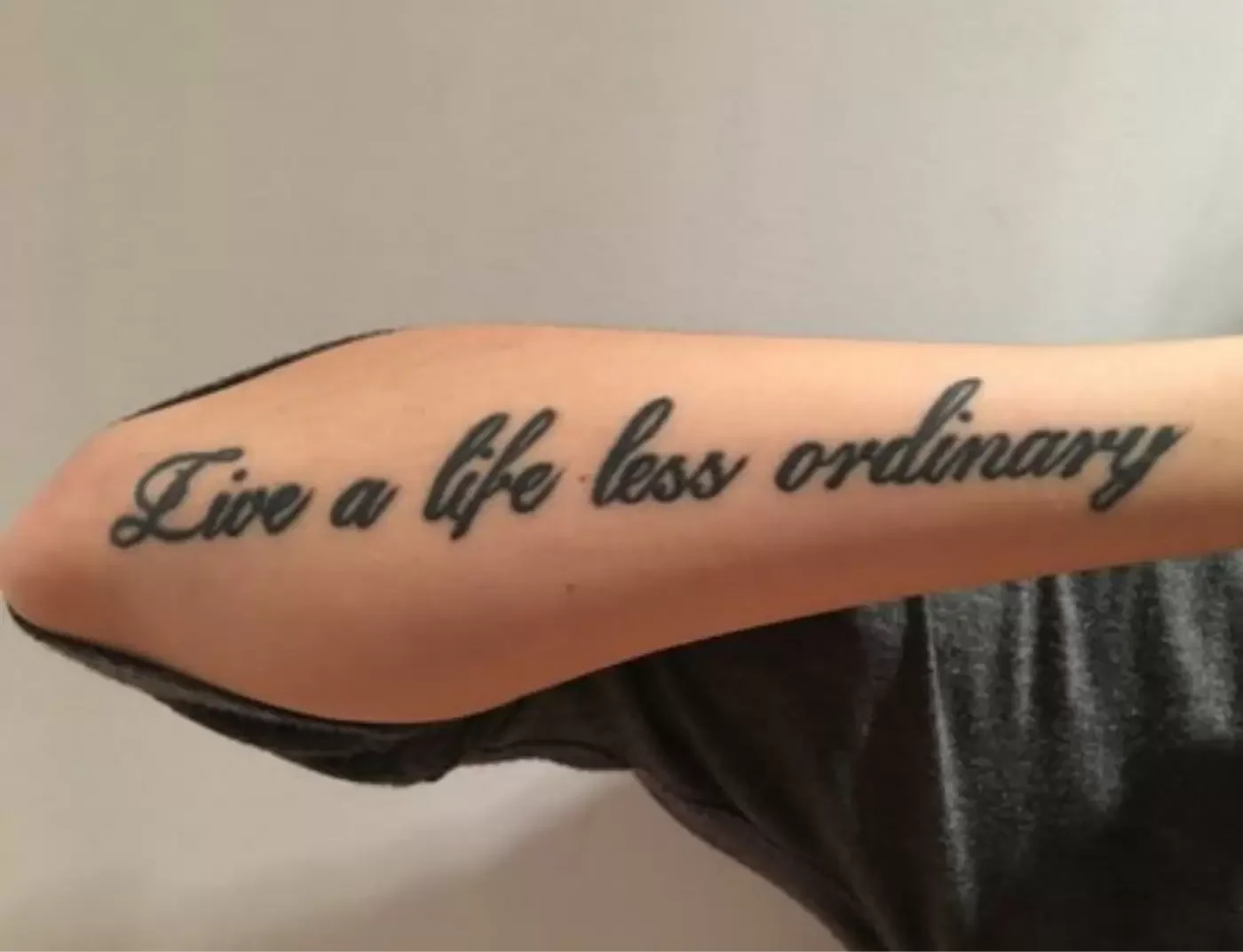 tattoo of live a life less ordinary text