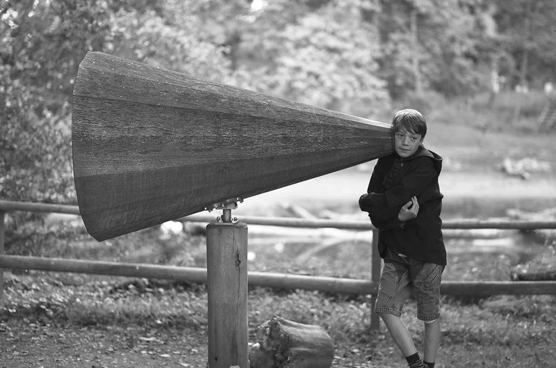 A boy listening through a listening device