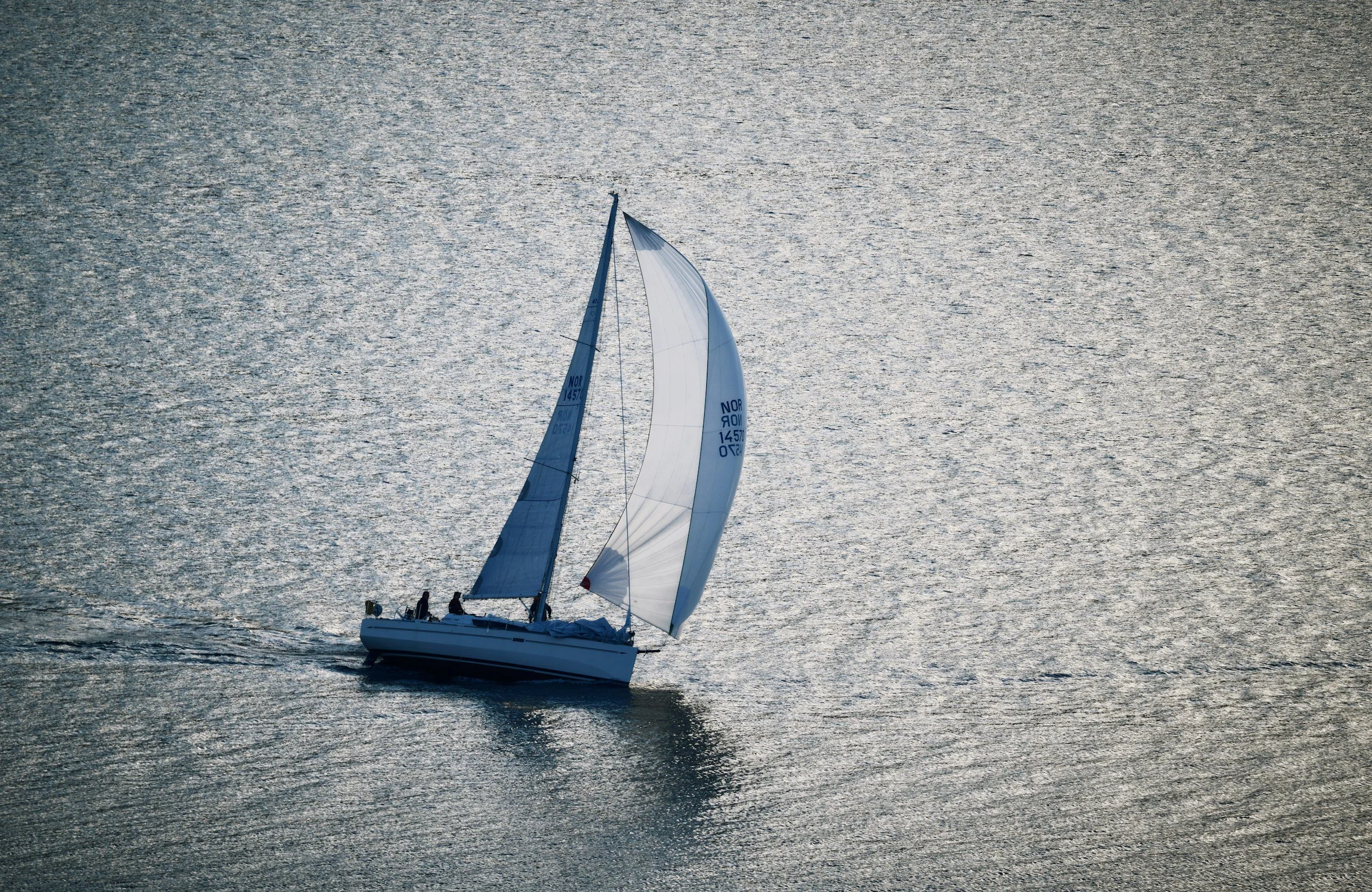 Sailboat on calm Bermuda waters at sunset, representing global insurance reach and navigation expertise