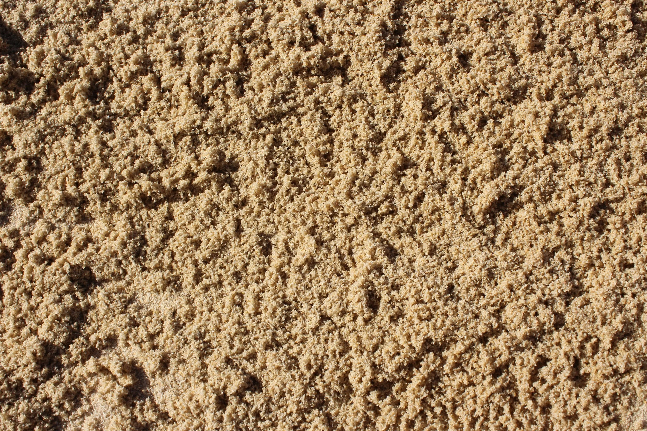 Nahaufnahme heller Sand mit kleinen Körnern.