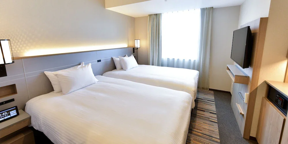 Compact twin-bed hotel room in a Japanese city hotel — Japan trip cost from Australia