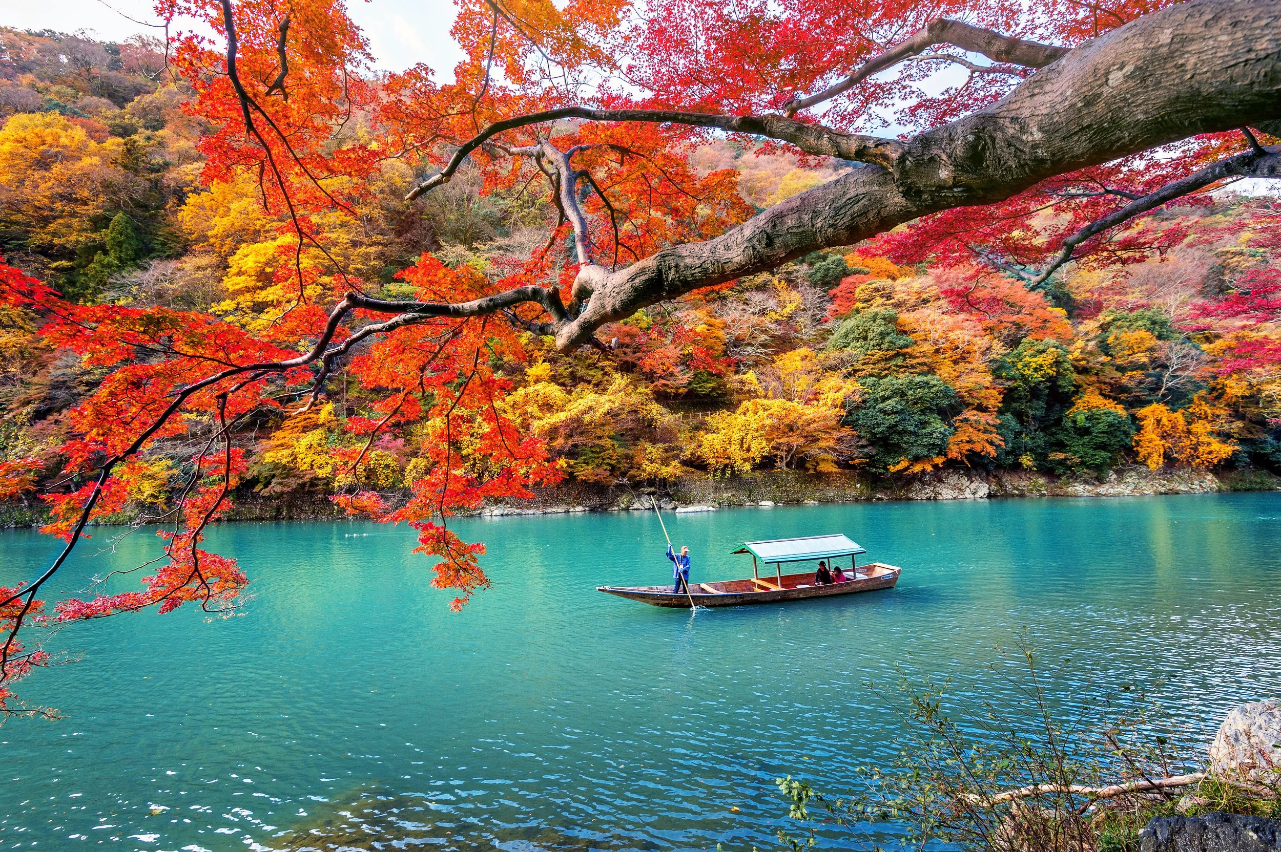 Autumn maple leaves framing lake with rowing boats in Japan — best time to visit Japan in autumn by a.o.mi collective