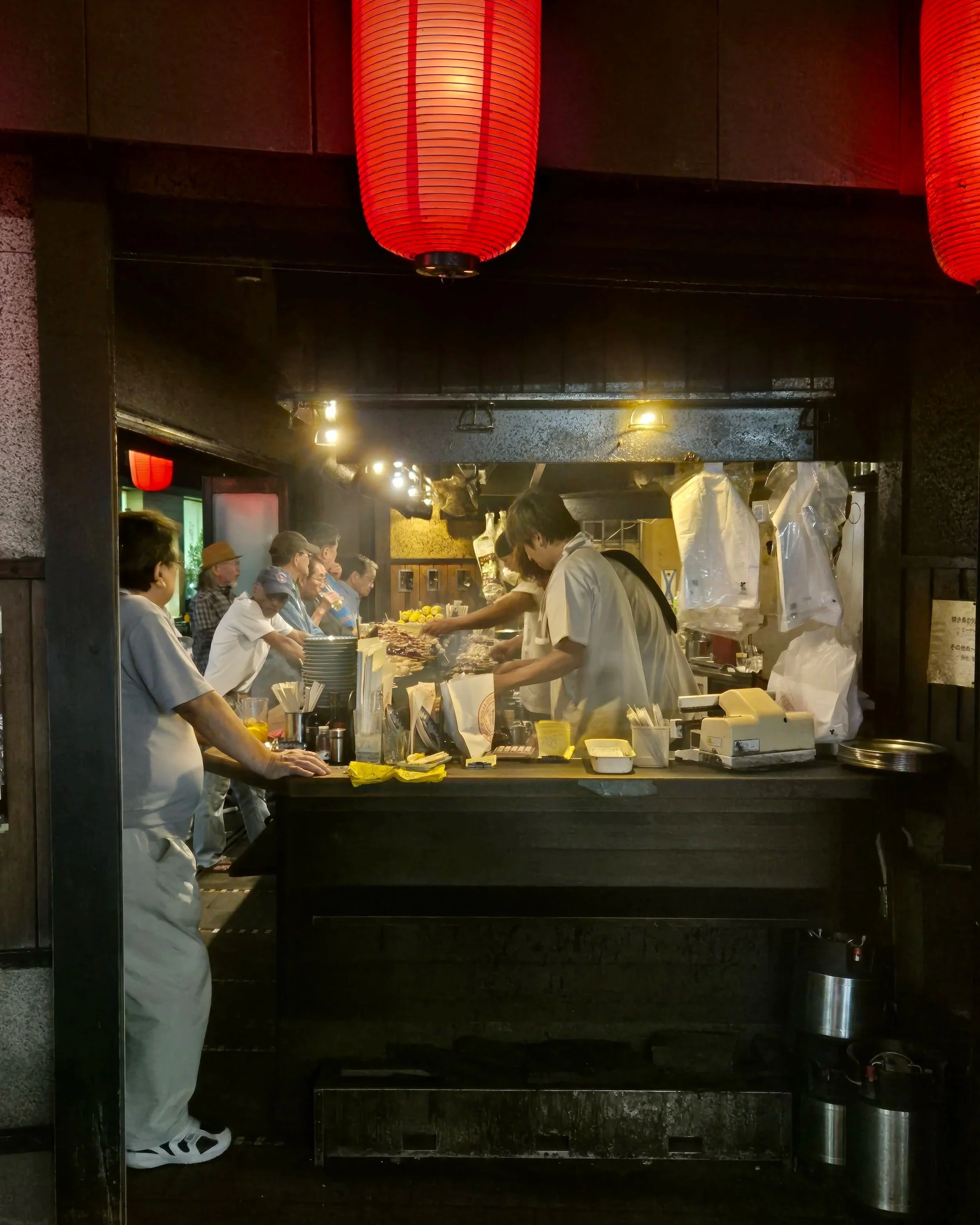Interior of a tachinomi standing bar in Kichijoji, Tokyo, locals gathered around the counter at night — Japan food guide