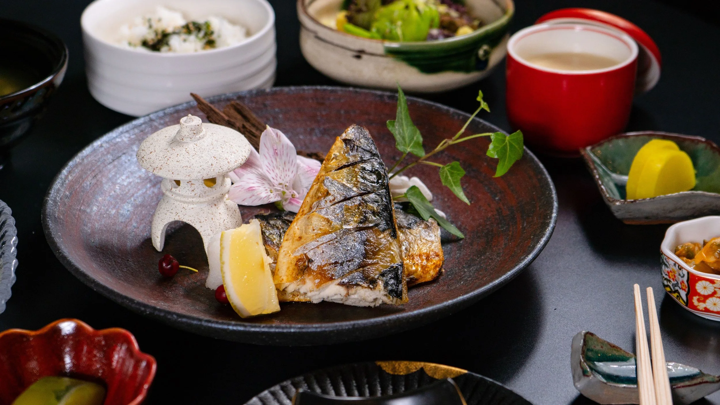 Kaiseki multi-course meal with grilled fish, seasonal sides and rice served at a Japanese ryokan