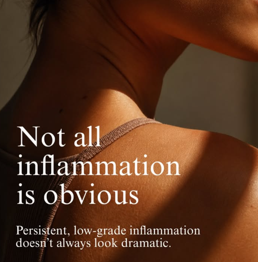 Ihmisen olkavarsi ja olkapää, vaatteet, rauhallinen tausta ja teksti, jossa lukee 'Not all inflammation is obvious. Persistent, low-grade inflammation doesn’t always look dramatic.'