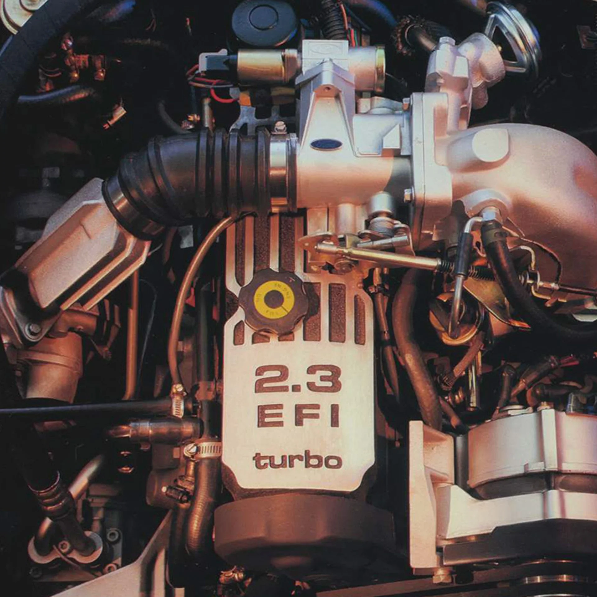 Close-up of a 2.3-liter turbocharged EFI engine in a car.