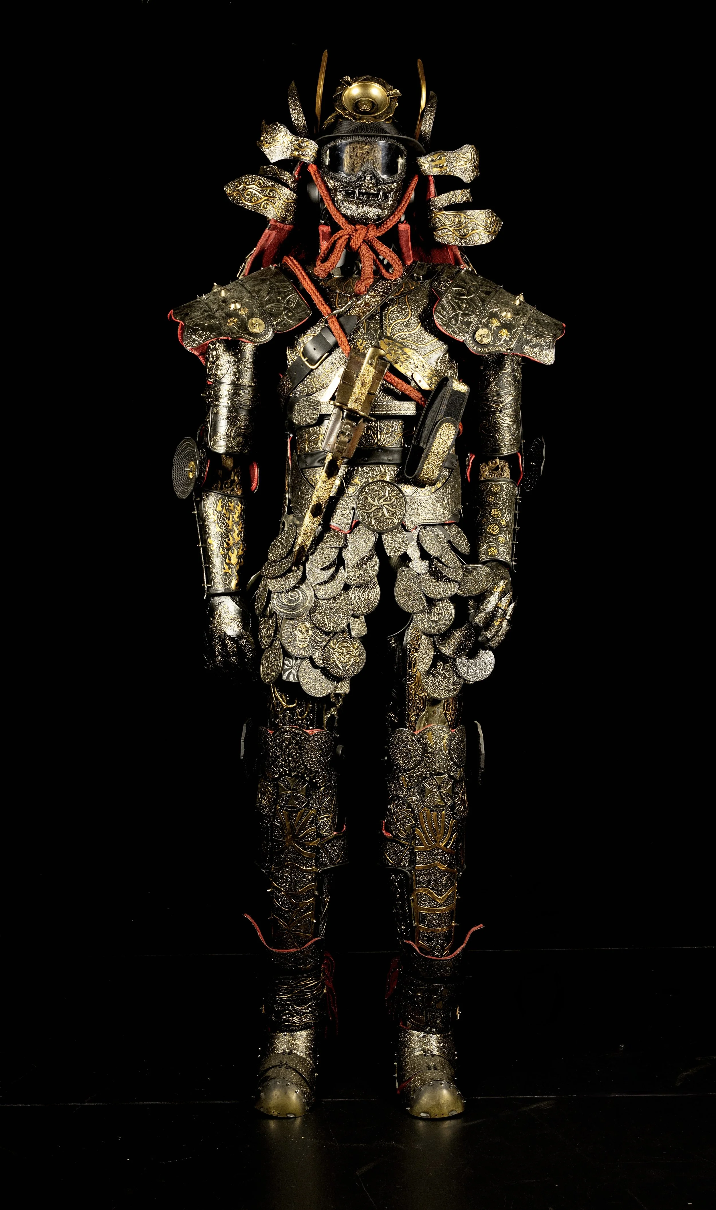 A samurai armor made of various metallic objects, coins, wristwatch elements and tools, with a black background.