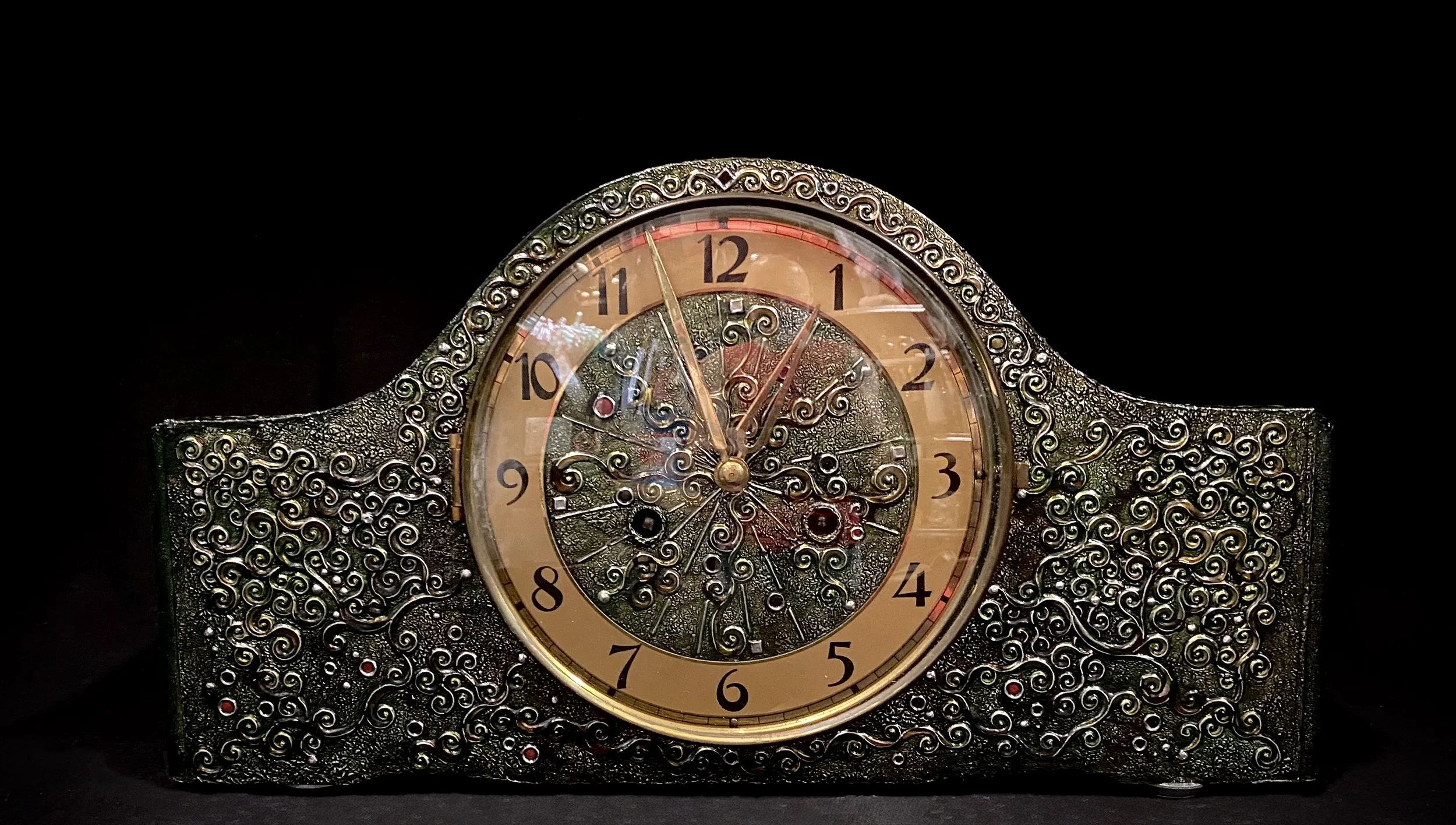 Decorative vintage clock with ornate metal frame and intricate swirling patterns