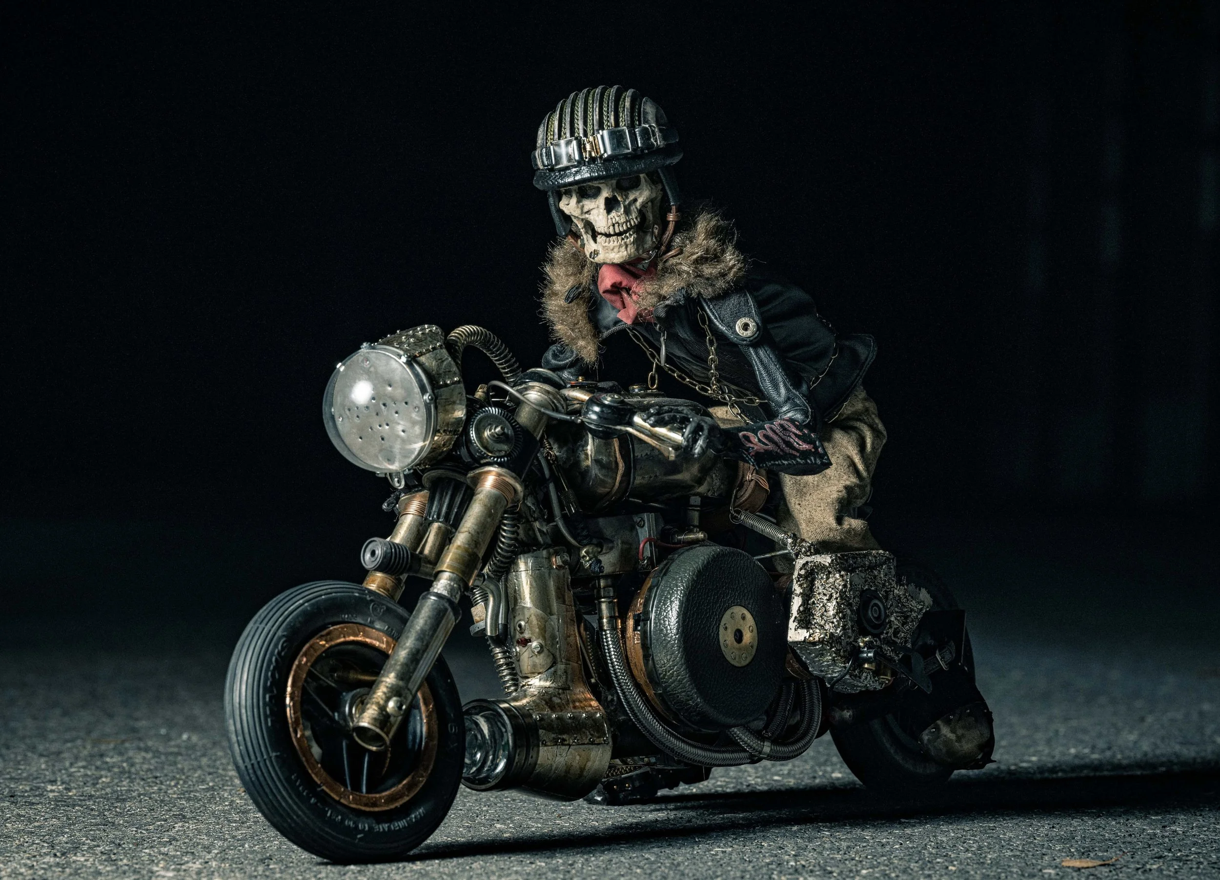 A skeleton with a helmet riding a custom-built vintage motorcycle on a dark road.