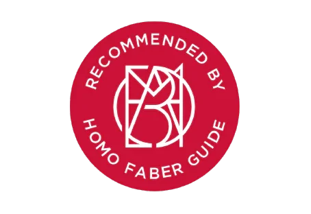 A red circular badge with white text that says "RECOMMENDED BY HOMO FABER GUIDE" and a white logo in the center.