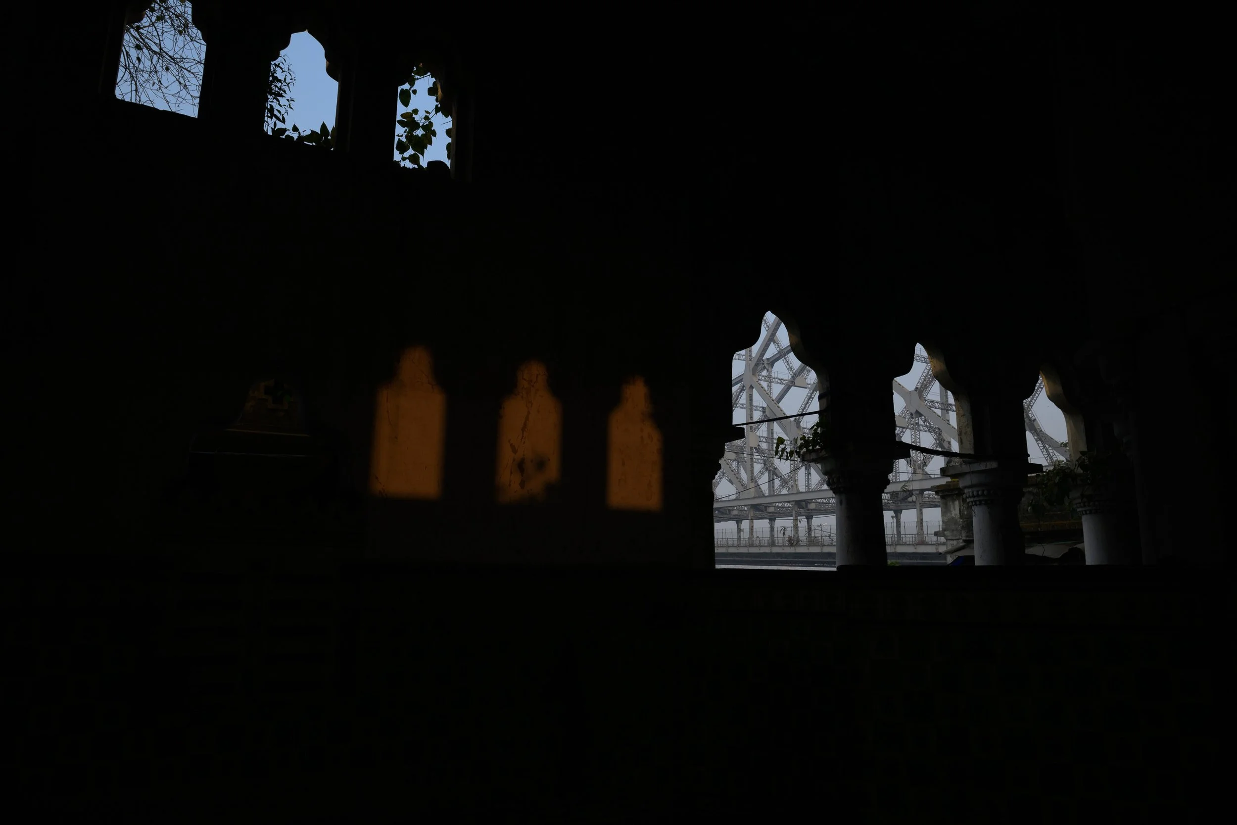View through a decorative window with a silhouette of an amusement park ride or roller coaster in the background.