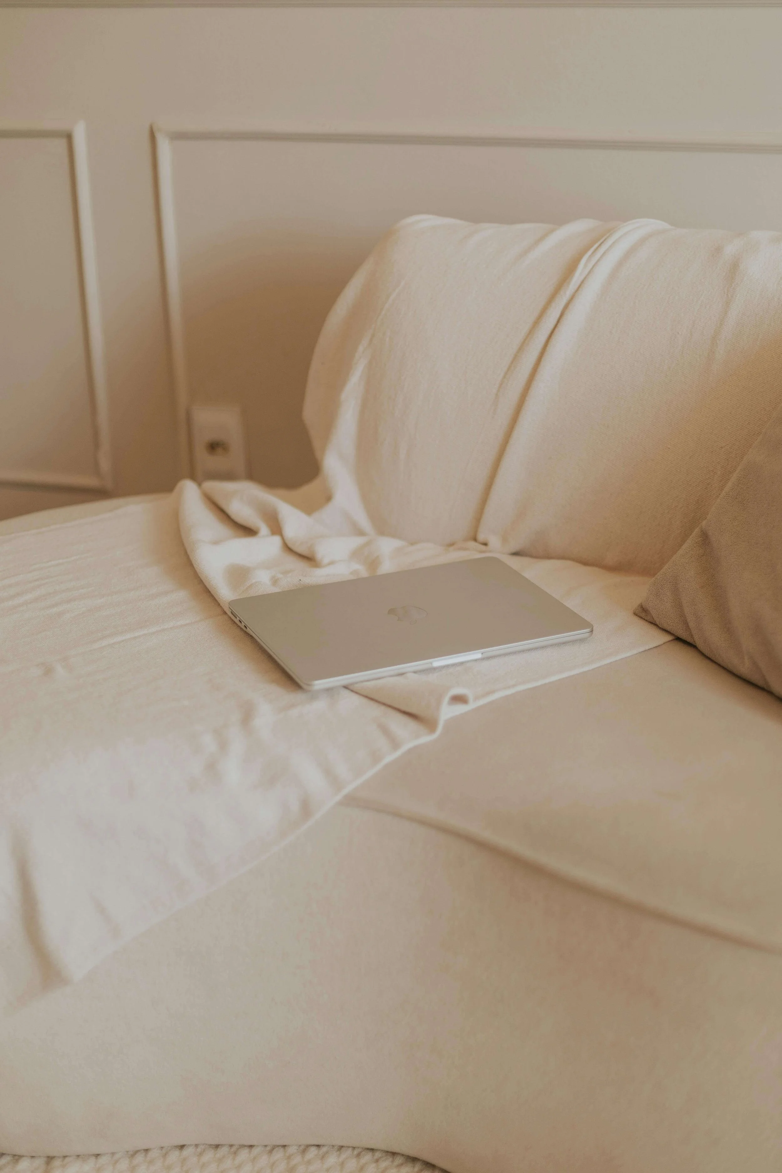 A laptop sitting on the couch in a new parent's house.