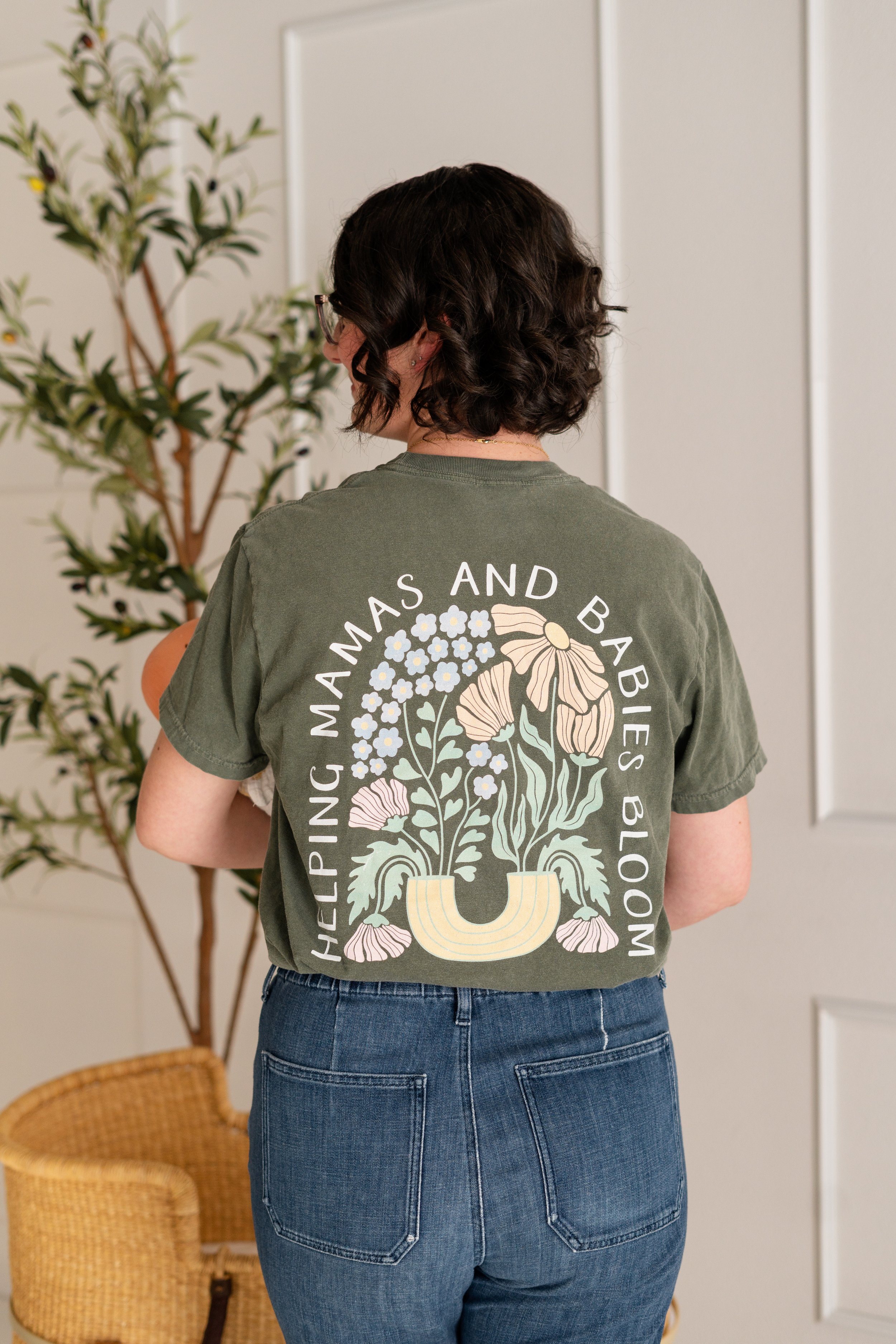 The back of Jenna's t-shirt says she helps mamas and babies bloom.