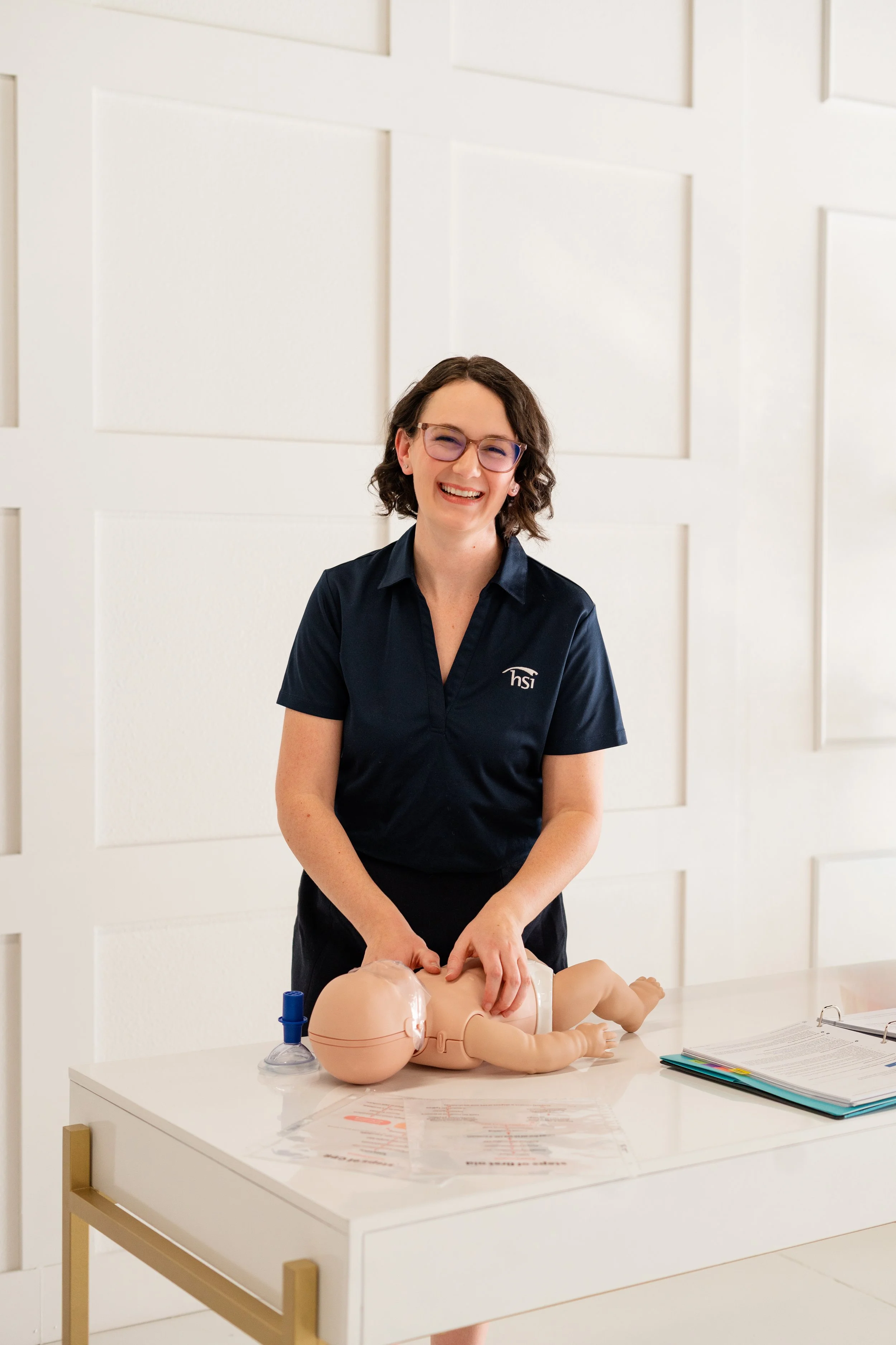 Jenna performing CPR compressions on an infant manikin.