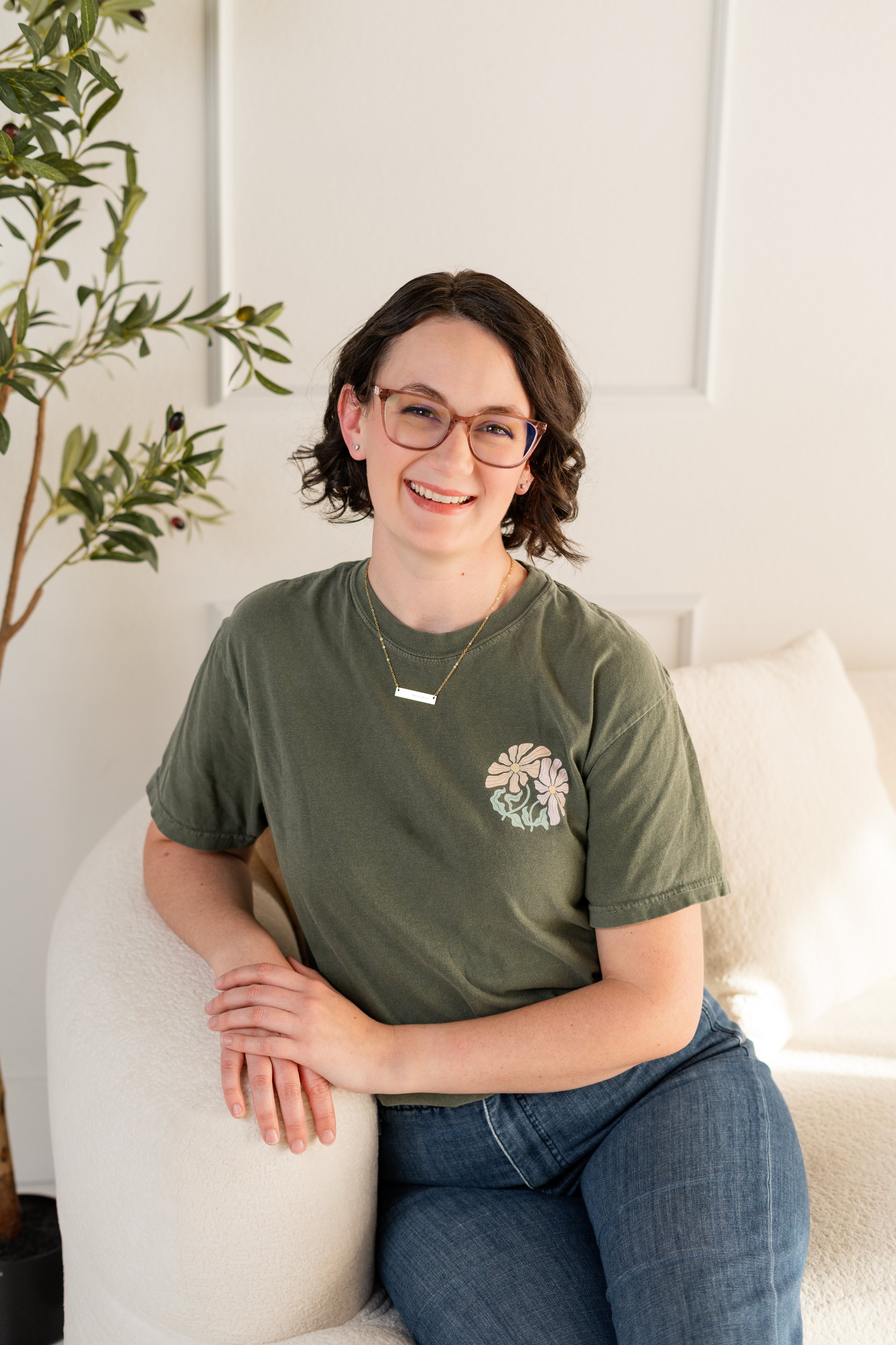 Jenna smiling while sitting at a postpartum doula client's house in Reno, NV.