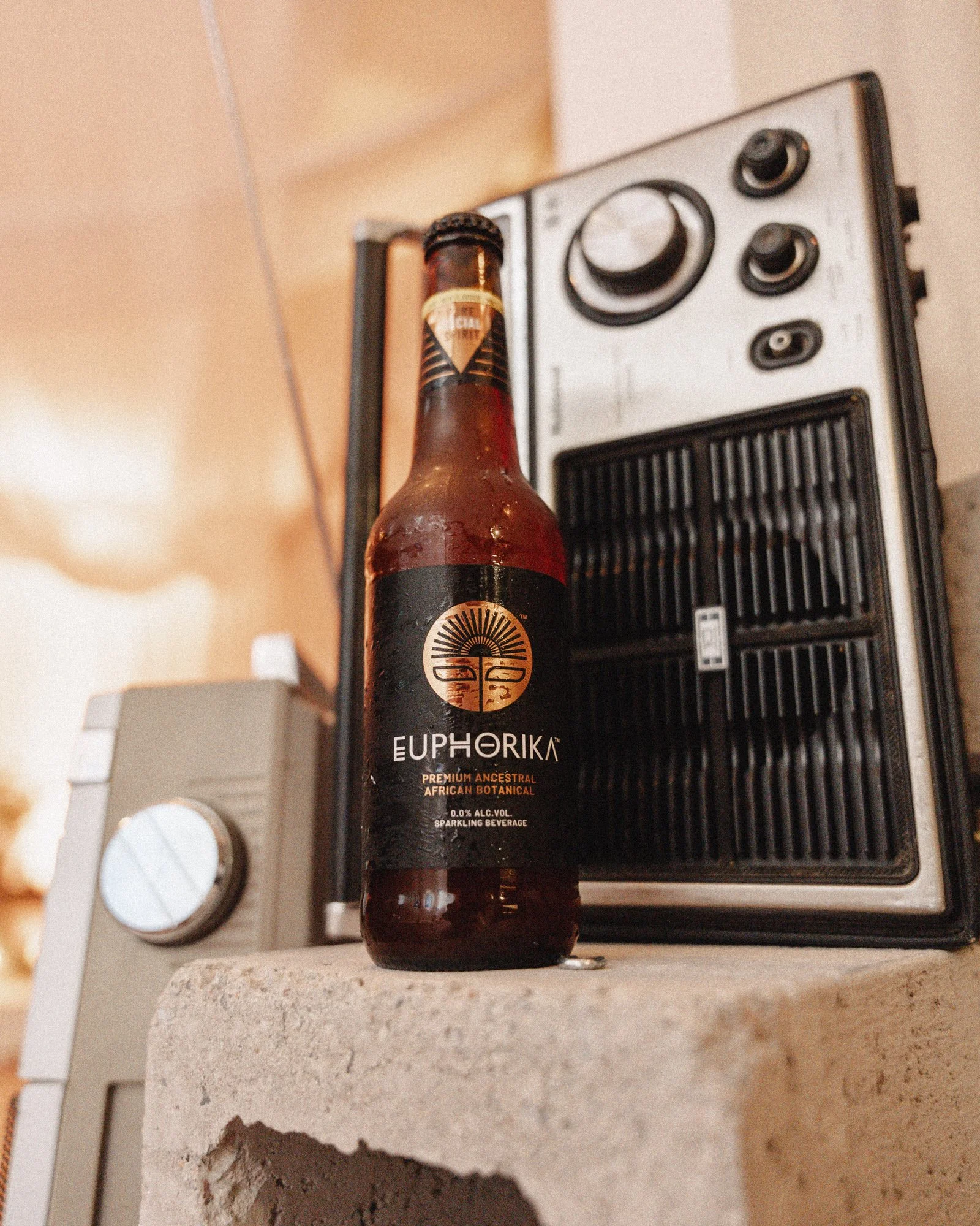 A dark glass bottle of Euphorika sparkling beverage with black and gold label, placed on a kitchen countertop next to a microwave oven.