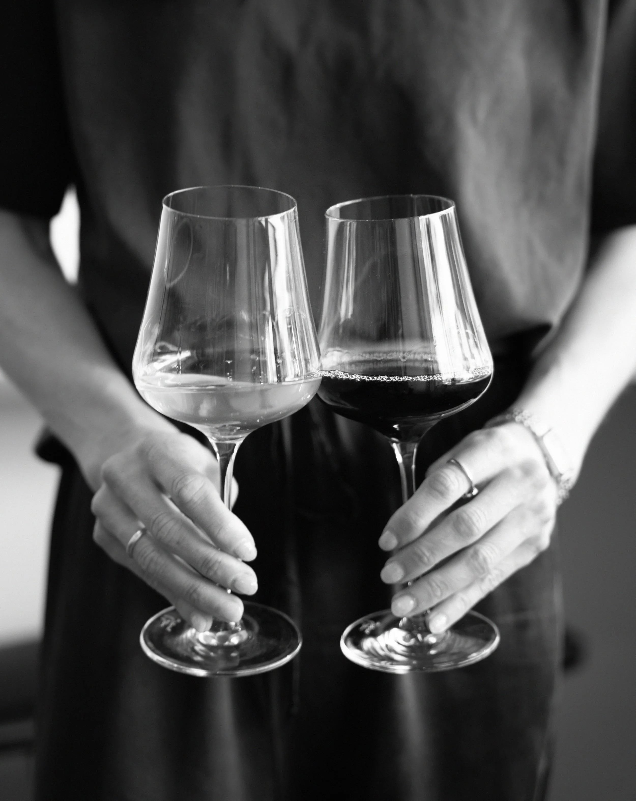 Brand campaign shoot for Melbourne small business Two people holding wine glasses, one with white wine and one with red wine, in black and white photograph.