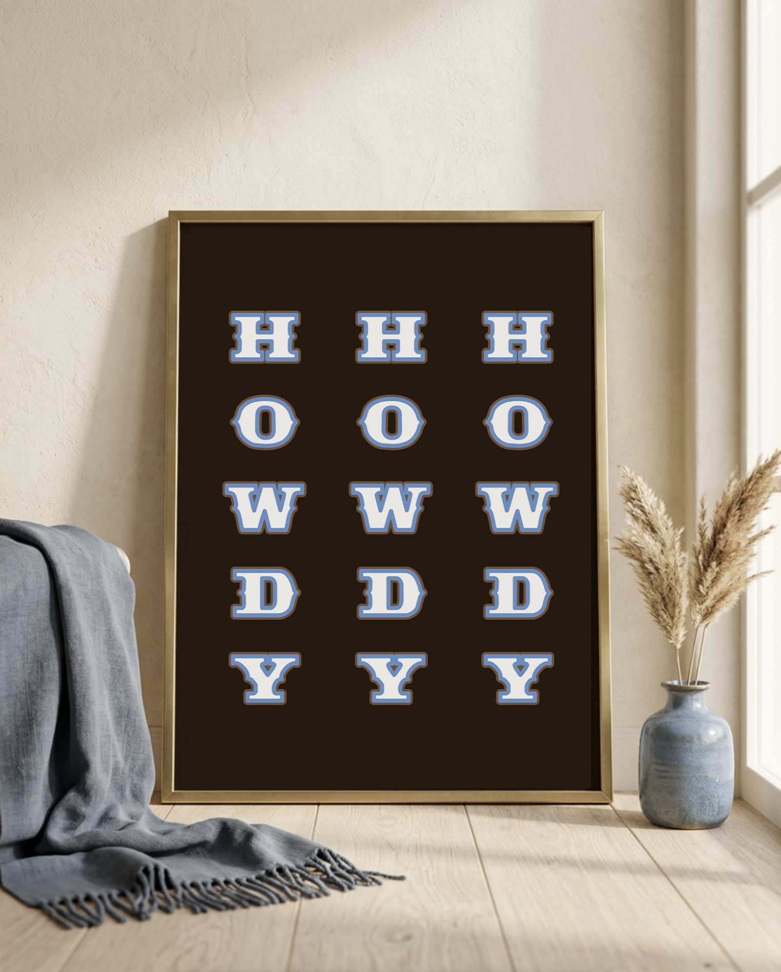 HOWDY western typography print, repeated letters in blue on dark brown, framed and leaning against a wall