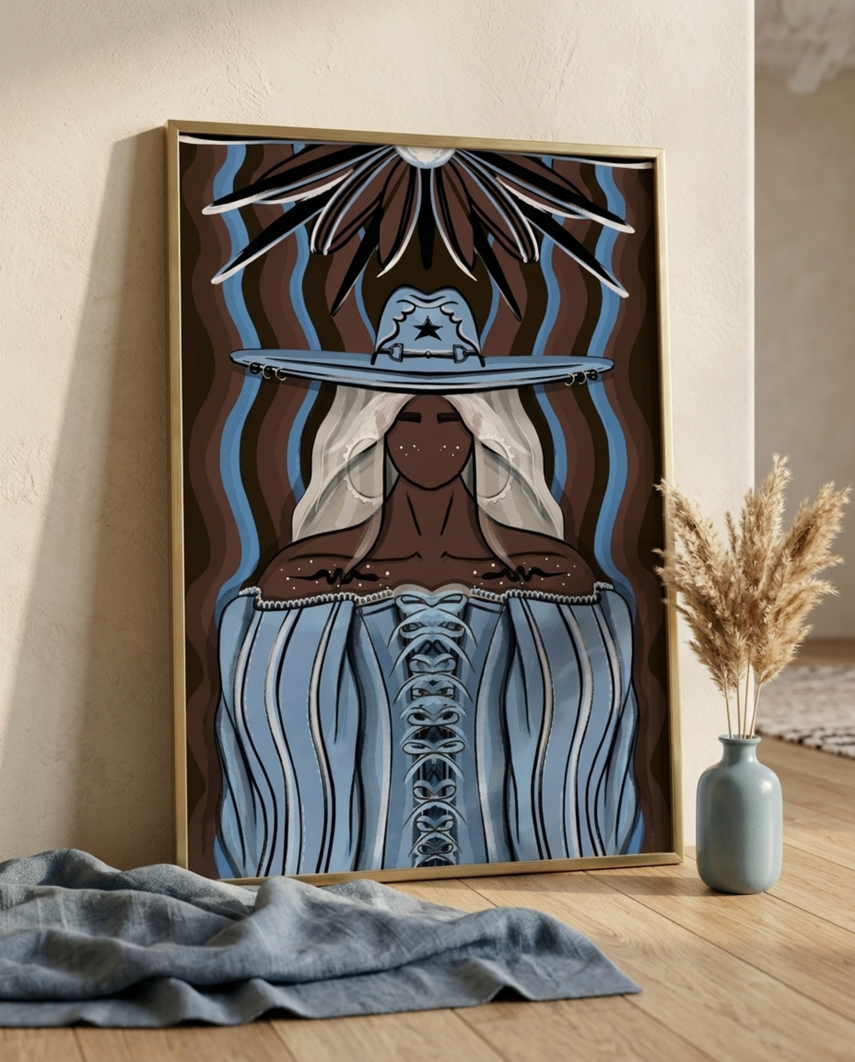 Western cowgirl portrait print in shades of blue and brown, framed and leaning against a wall with dried pampas grass