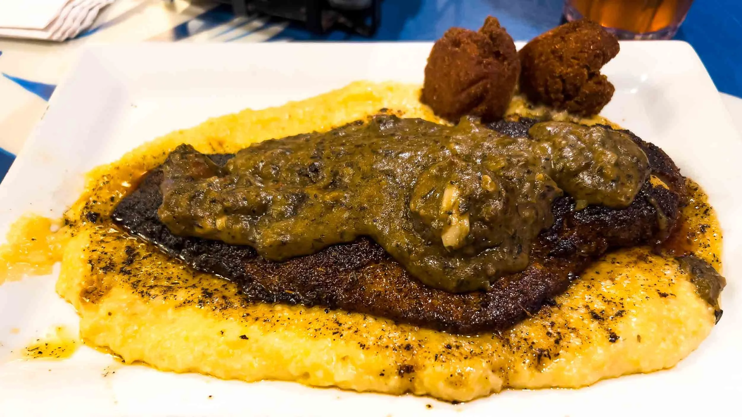 Fish Camp Grill Dinner: Fish and Grits - blackened red snapper served with cheesy grits, etouffee sauce and a side of hush puppies.
