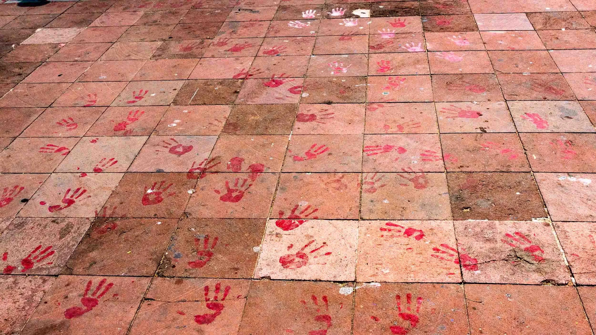 April 25, 2025: The Church of La Crucecita courtyard. Red hand prints left behind from past civil protest, usually protesting violence or requiring some form of social justice.